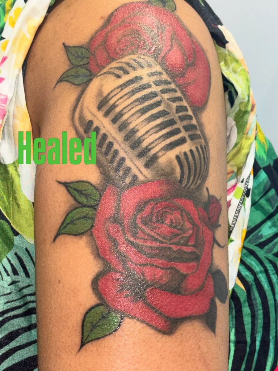 Microphone and roses American traditional tattoo on the shoulder by Jones Eric