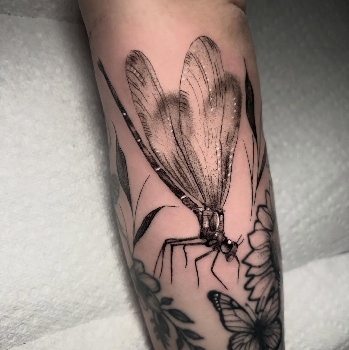Dragonfly black and grey tattoo on the forearm by Ashley Denise