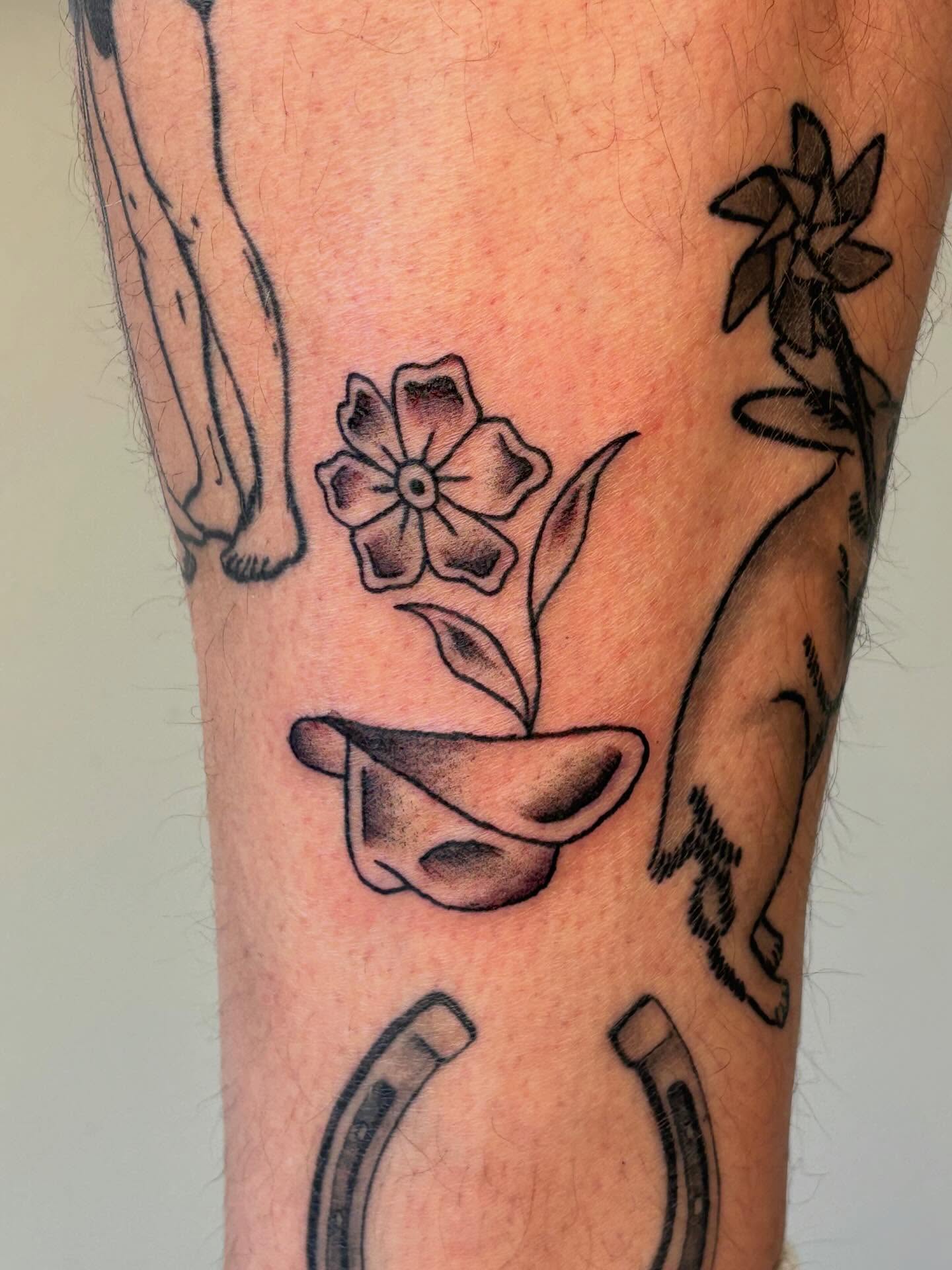 Flower in pot black and grey tattoo on the forearm by Topher Belmont