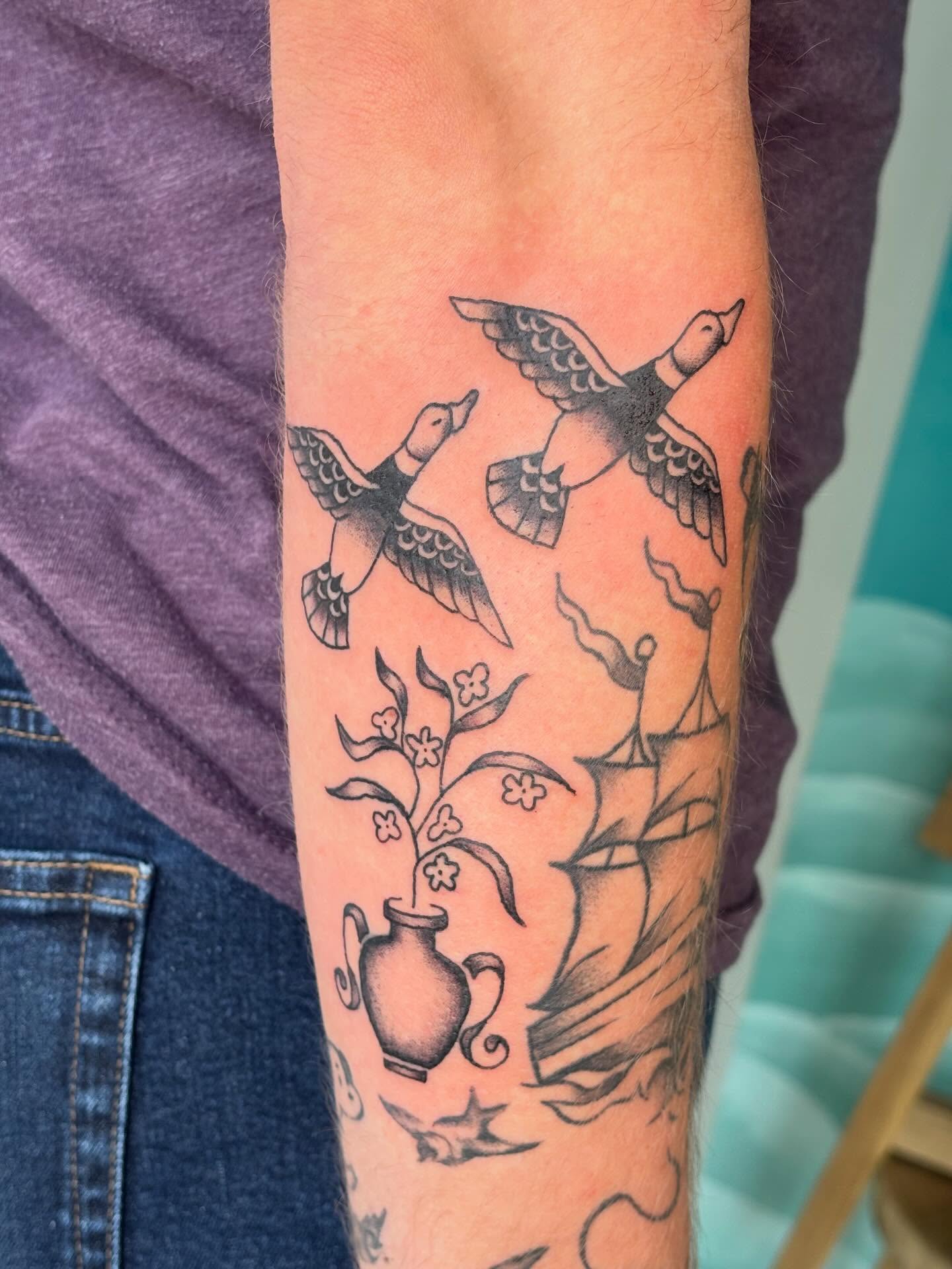 Ducks and ship black and grey tattoo on the forearm by Topher Belmont