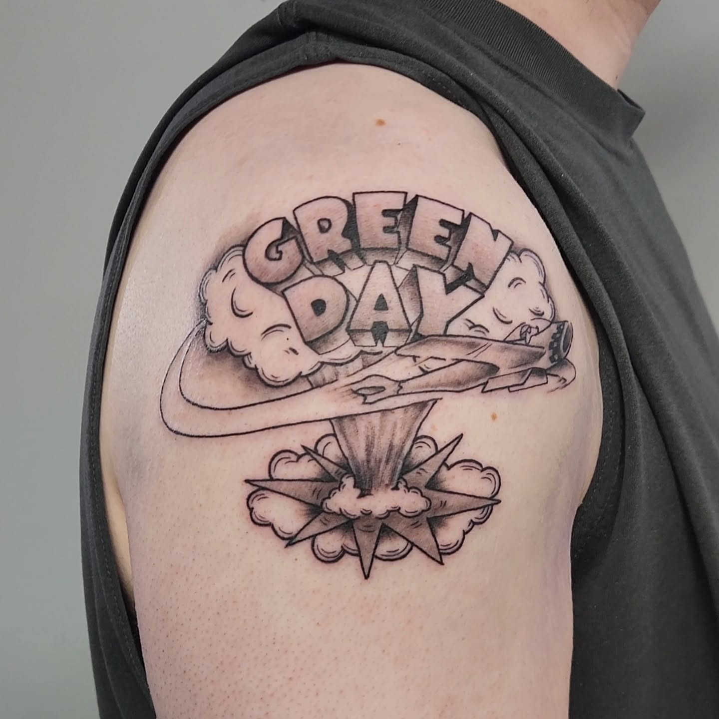 Green Day logo black and grey tattoo on the shoulder by Jason August