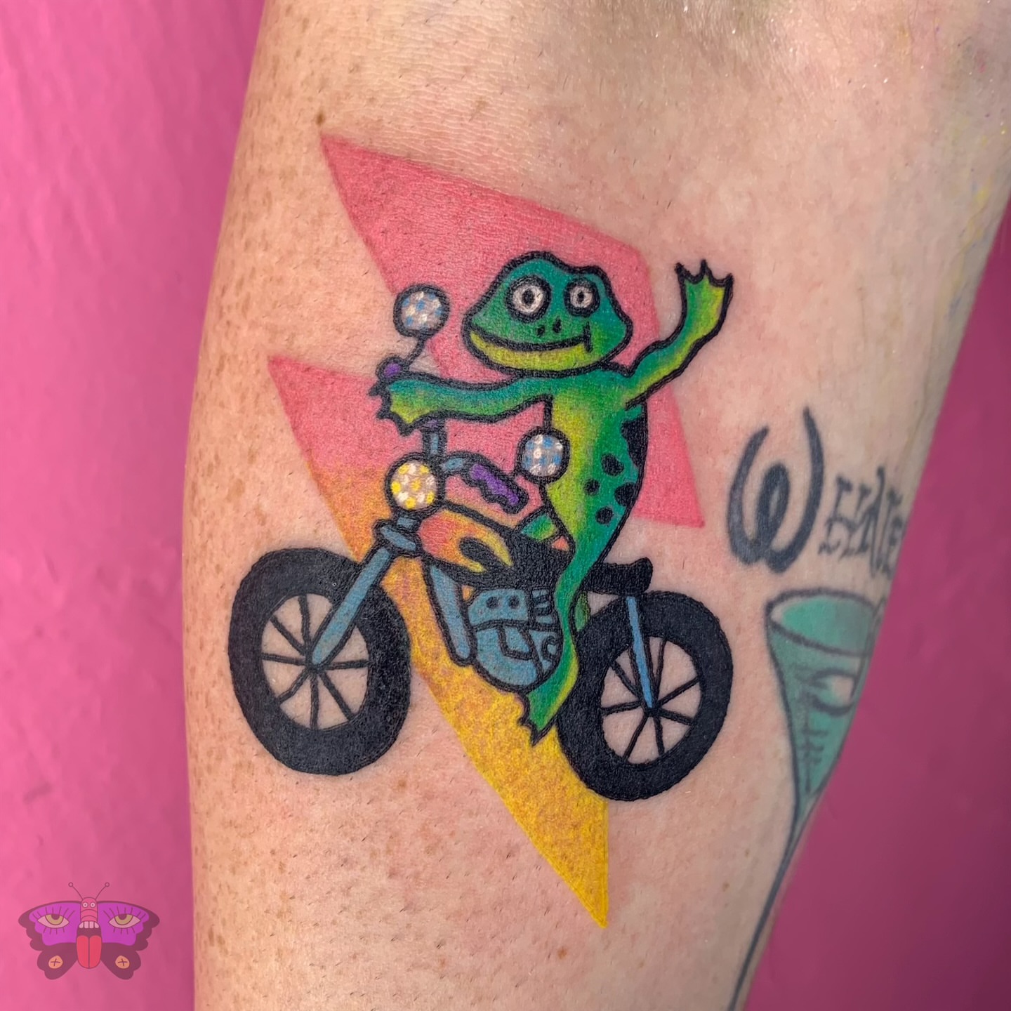Frog riding motorcycle new school tattoo on the forearm by Jess Koala, San Francisco, California