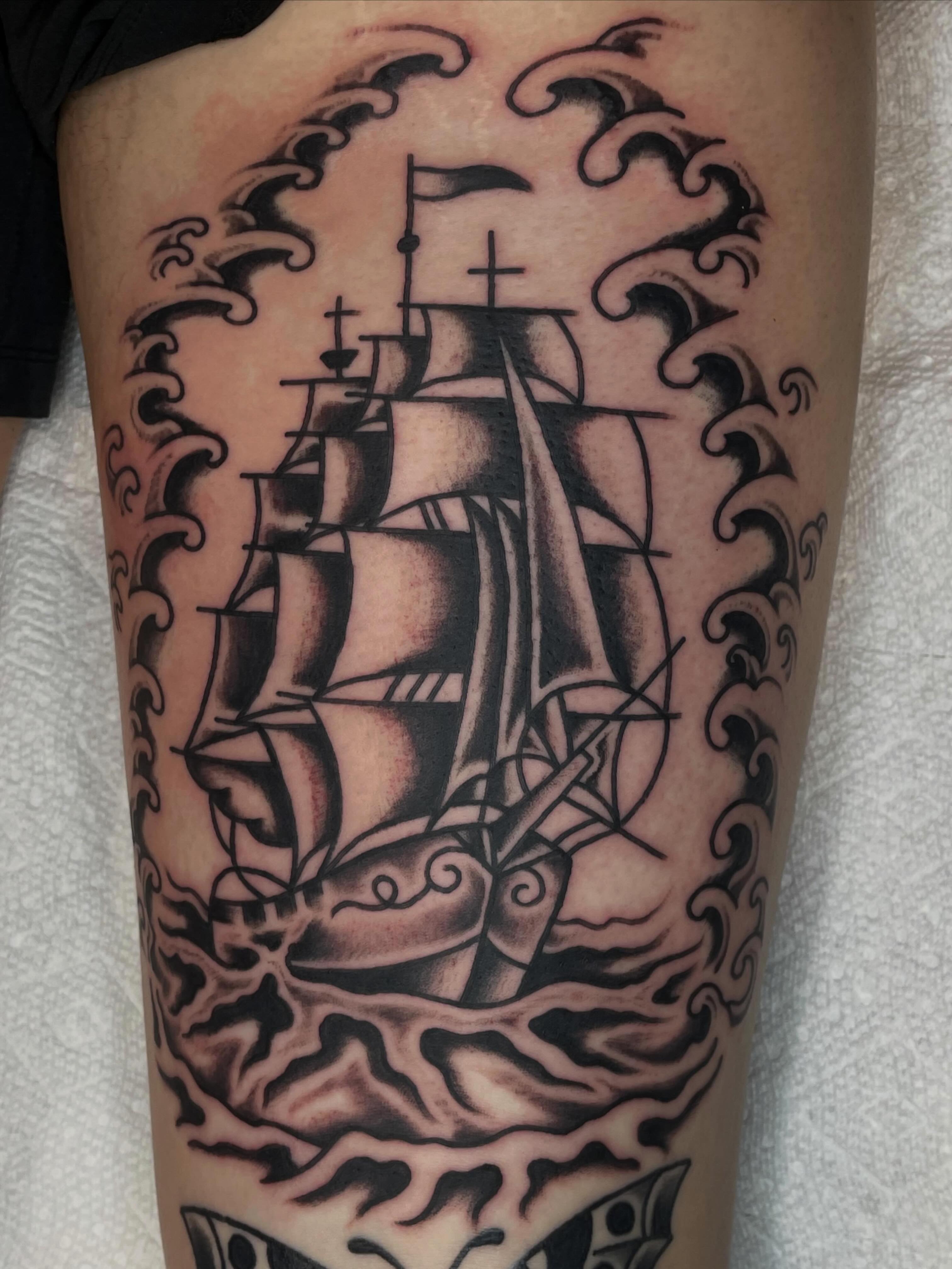 Ship sailing through waves black and grey tattoo on the leg by Nicholas M. Passeri