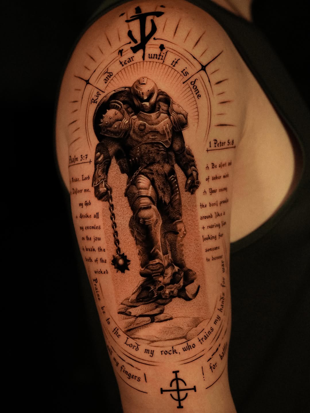 Doom Slayer with religious text tattoo on the upper arm by Nikita Grinenko, San Francisco