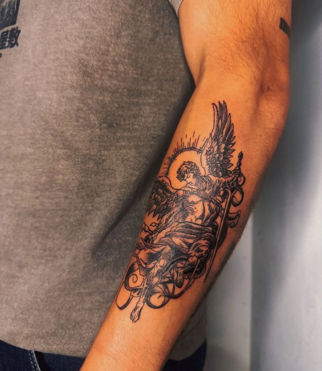 Angel with sword realism tattoo on the forearm by Comet