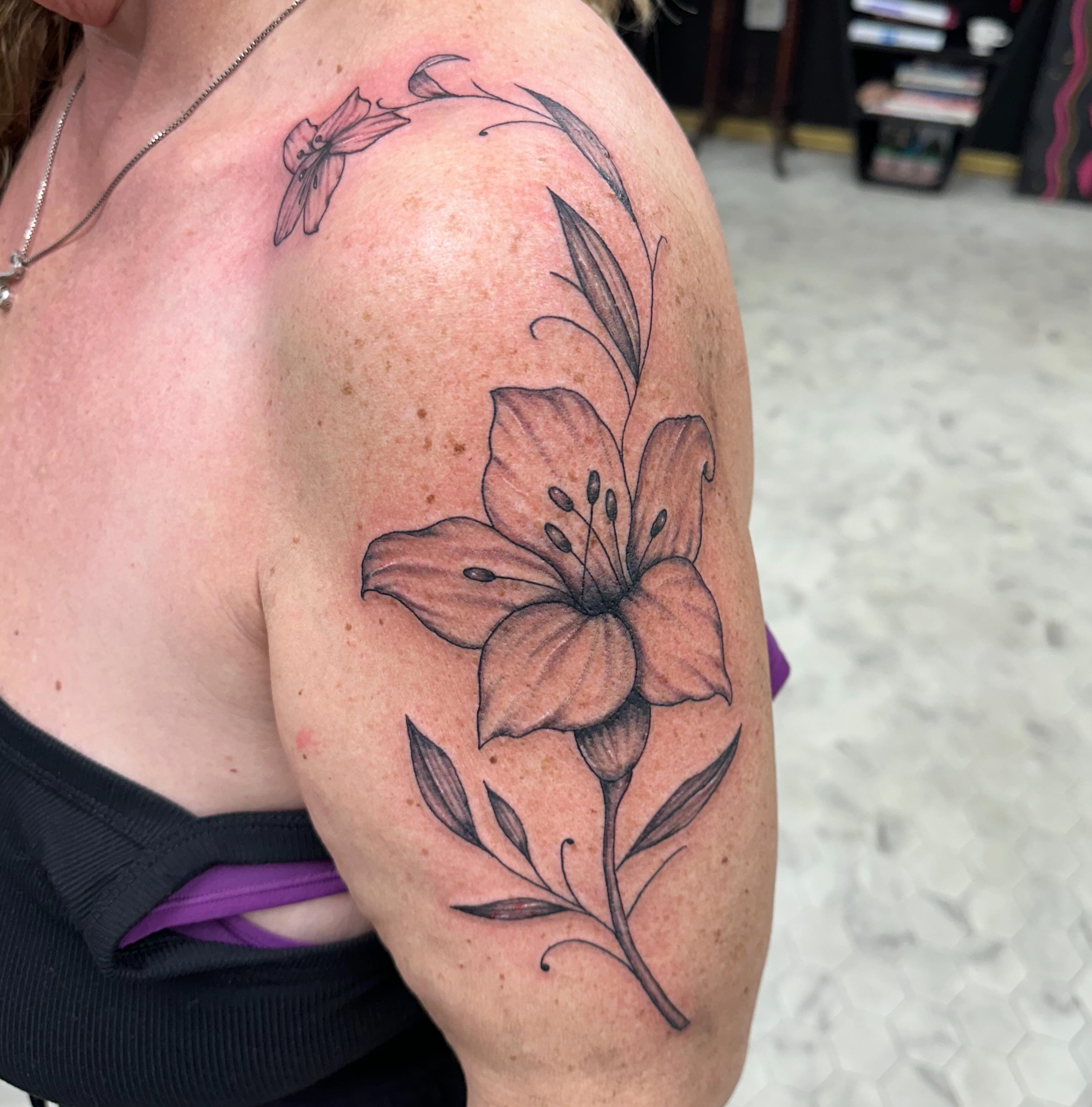 Lily black and grey tattoo on the shoulder by Nicki Hoverson