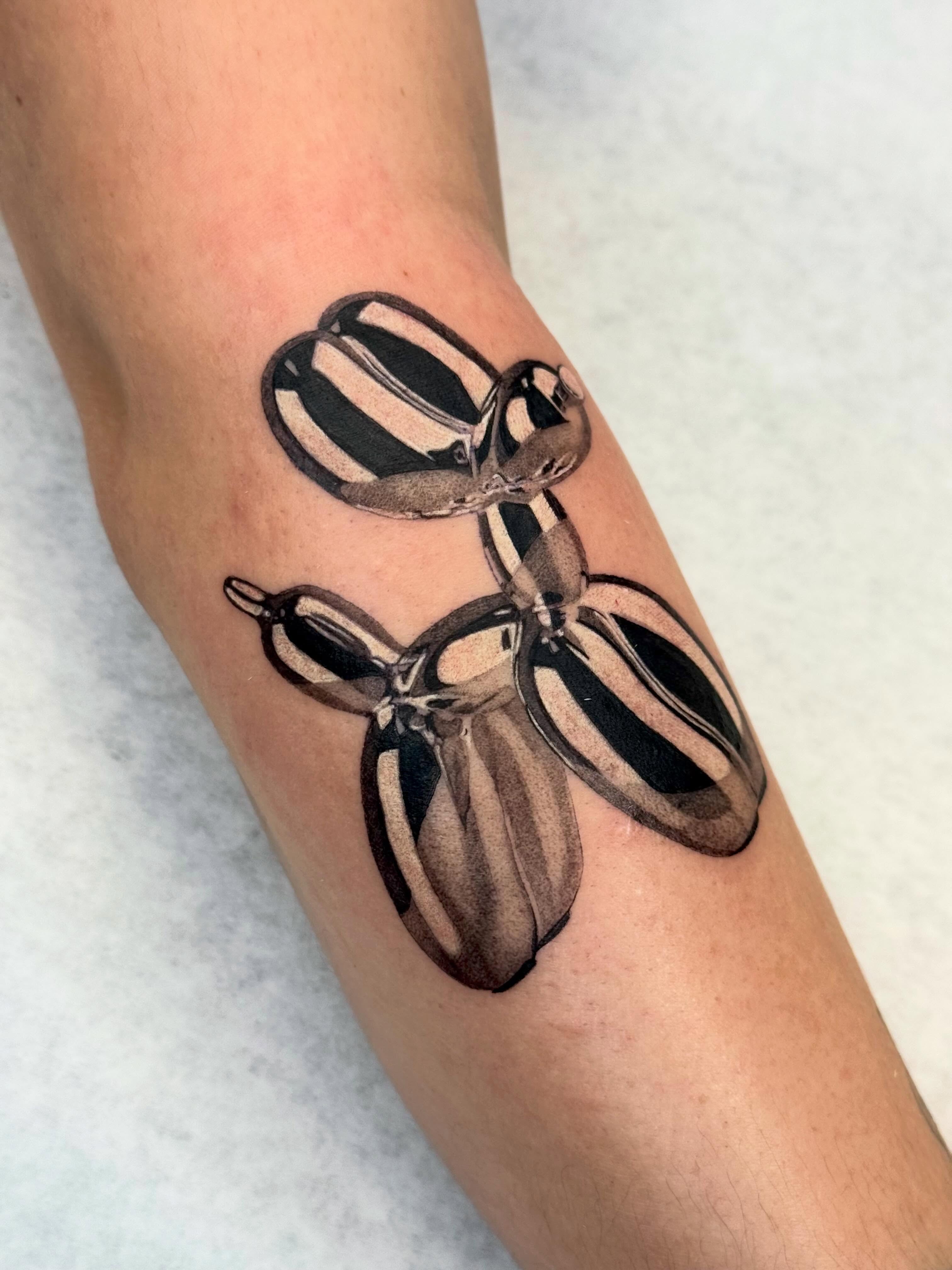 Balloon animal black and grey tattoo on the forearm by Em Krieg