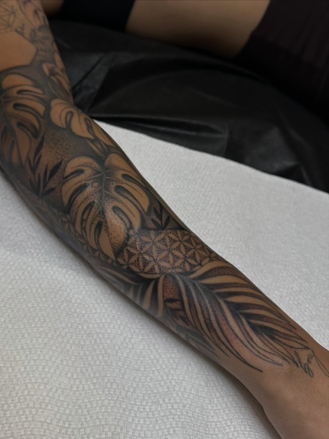 Monstera leaves and feather ornamental tattoo on the forearm by Ciera Farni, Murray, Utah