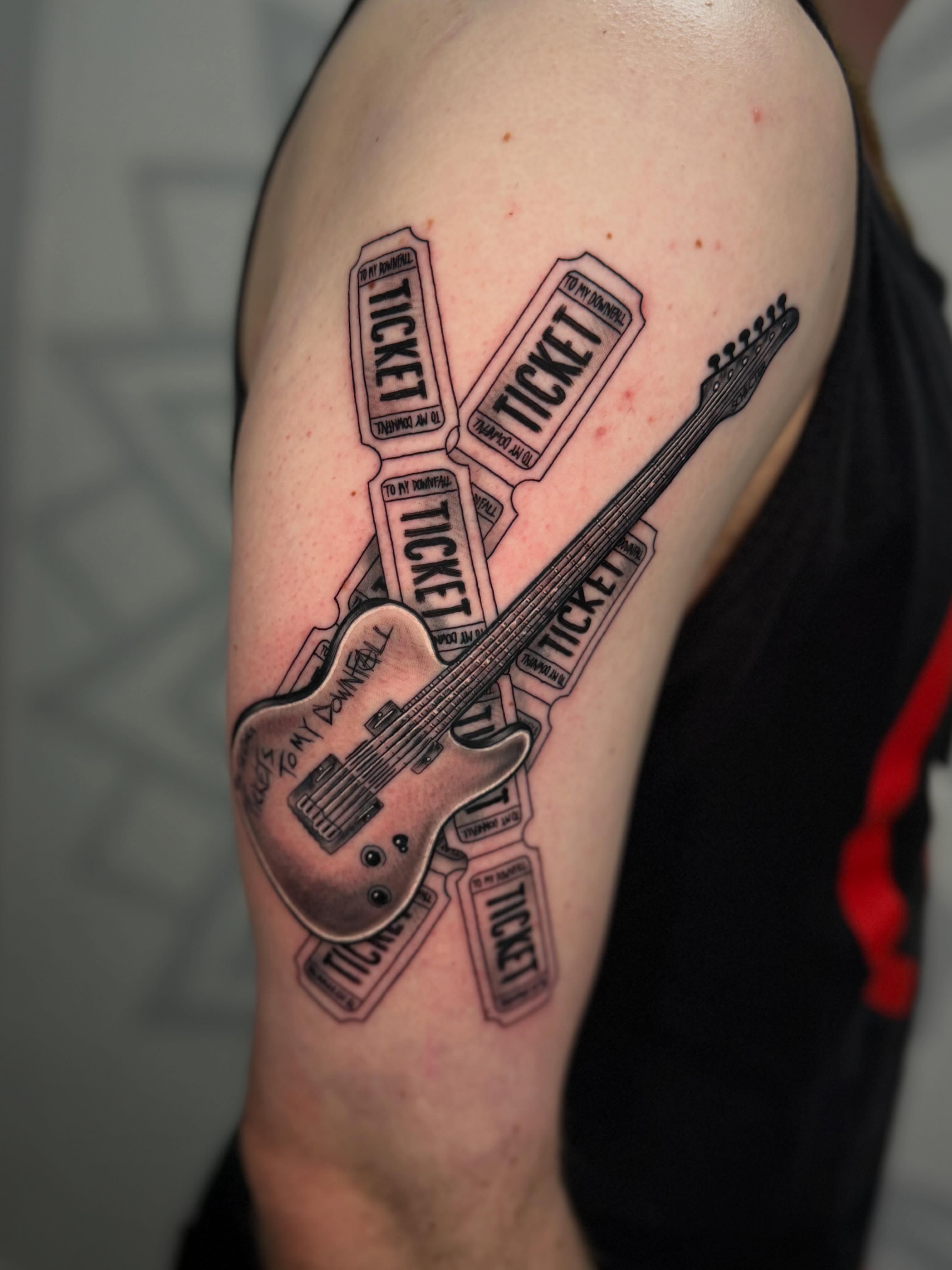 Guitar and tickets realism tattoo on the upper arm by Las Vegas Tattoo Artist, Las Vegas, Nevada
