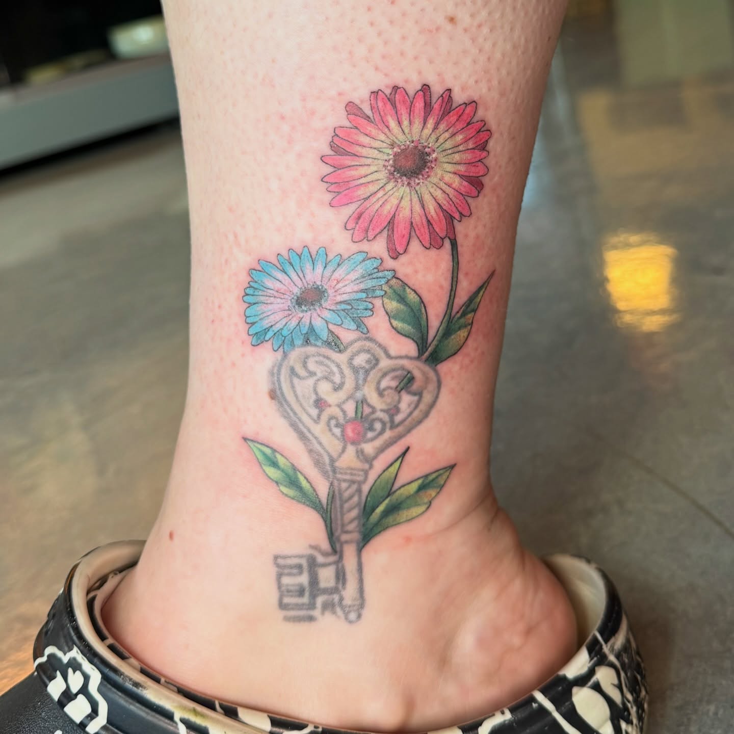 Key and flowers new school tattoo on the foot by iz fisch