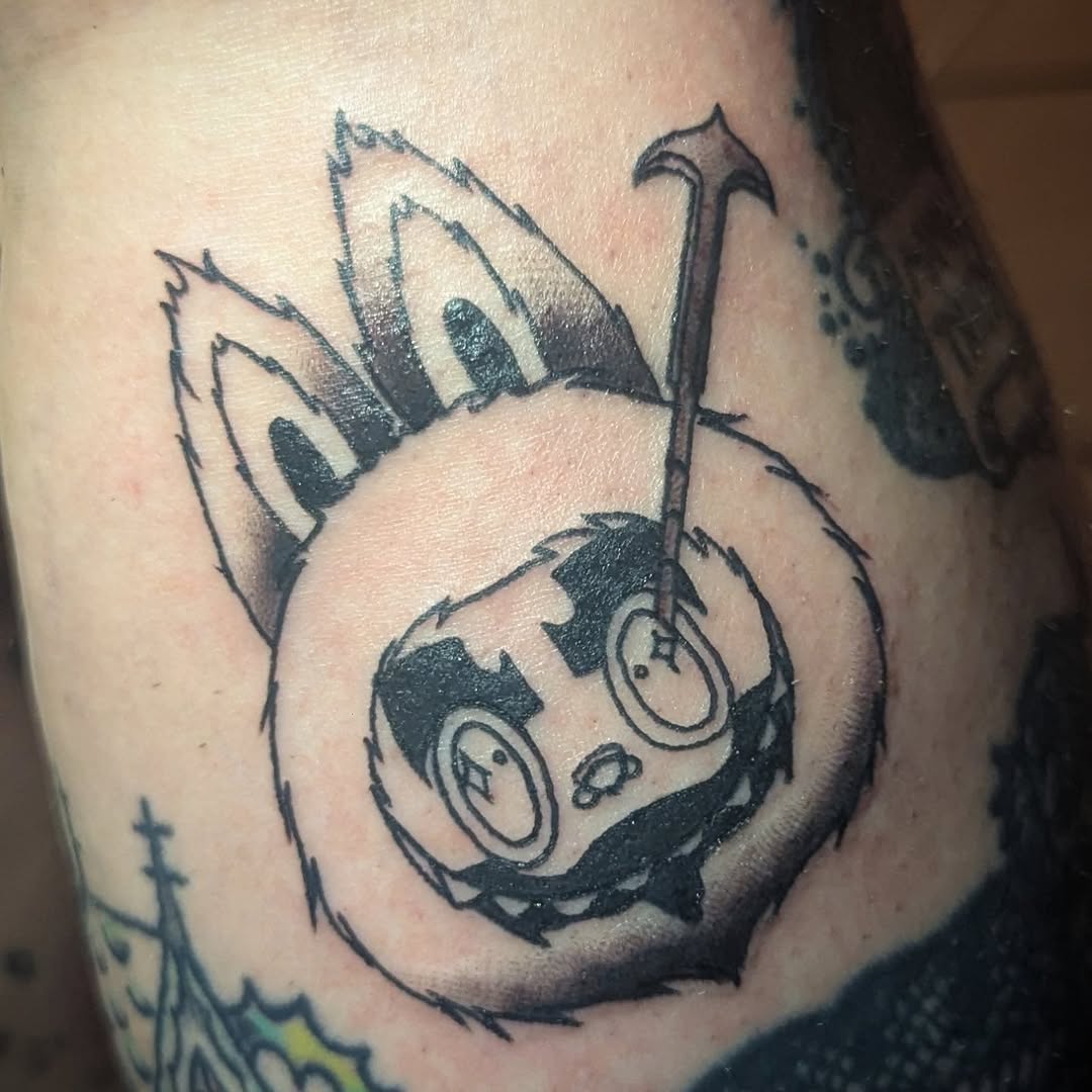 Creepy cartoon character with hammer dark art tattoo on the forearm by Payton