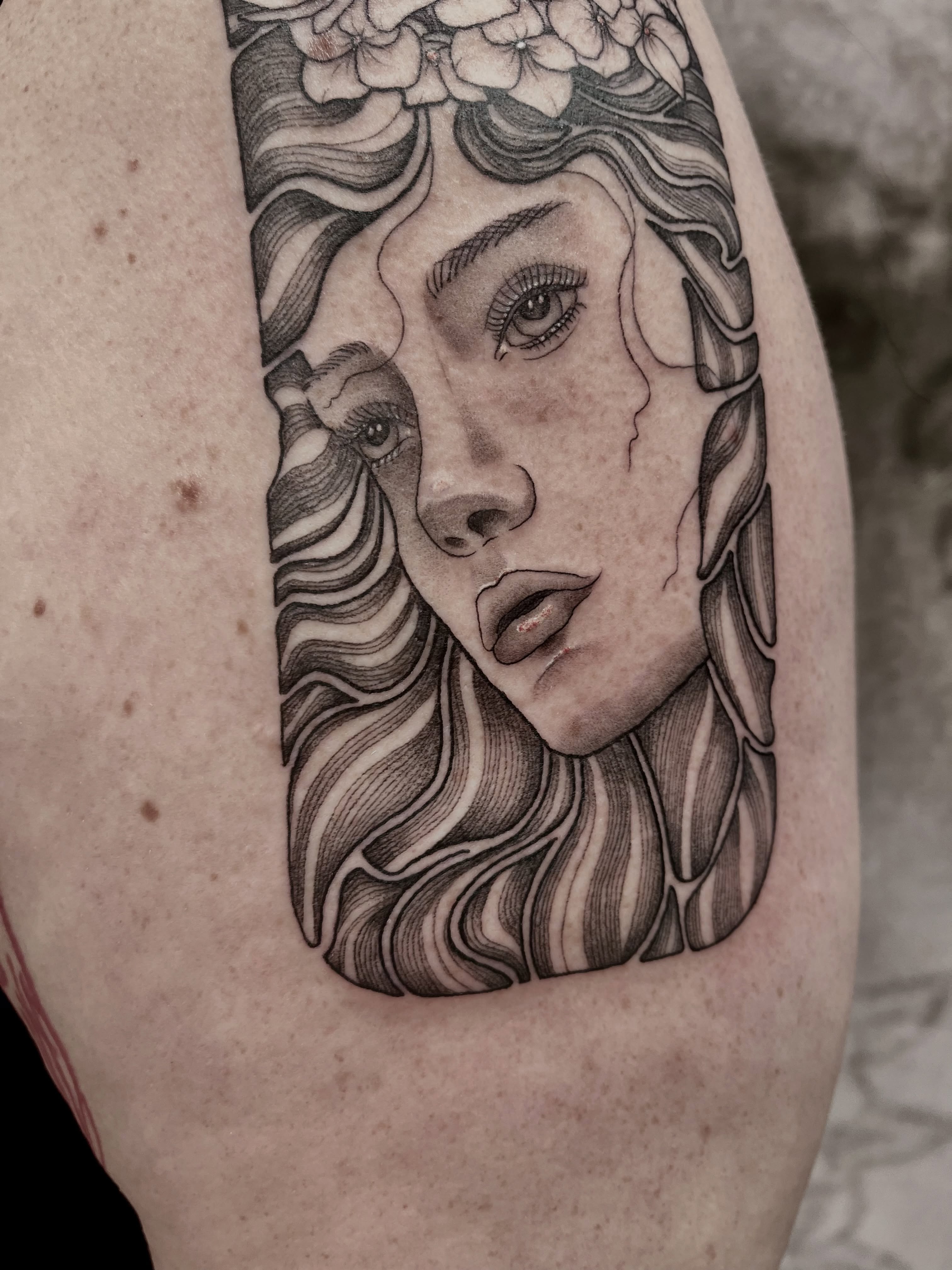 Woman's face realism tattoo on the thigh by Lo Gwynn