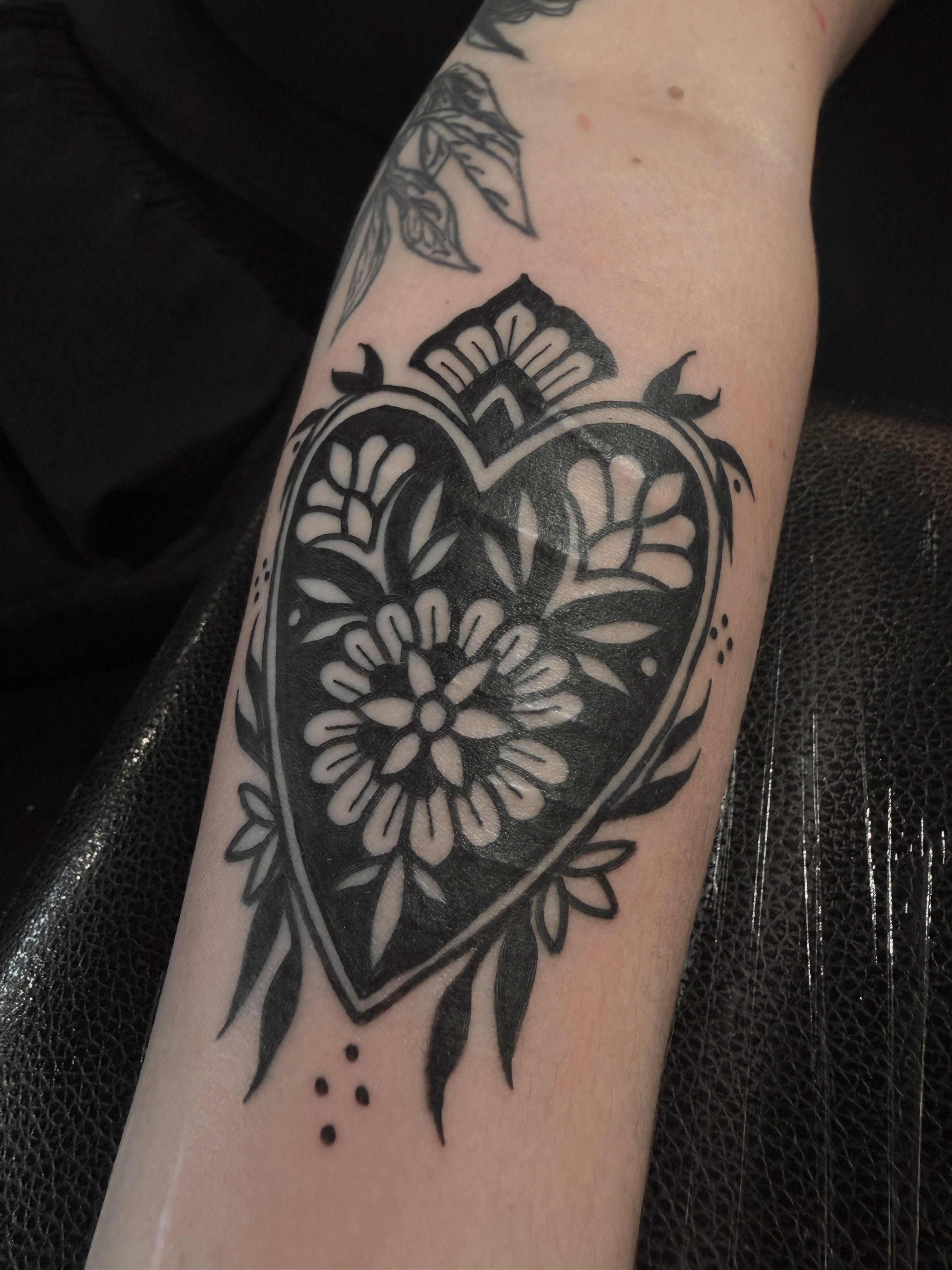 Heart with floral design black and grey tattoo on the forearm by Alex Cantor