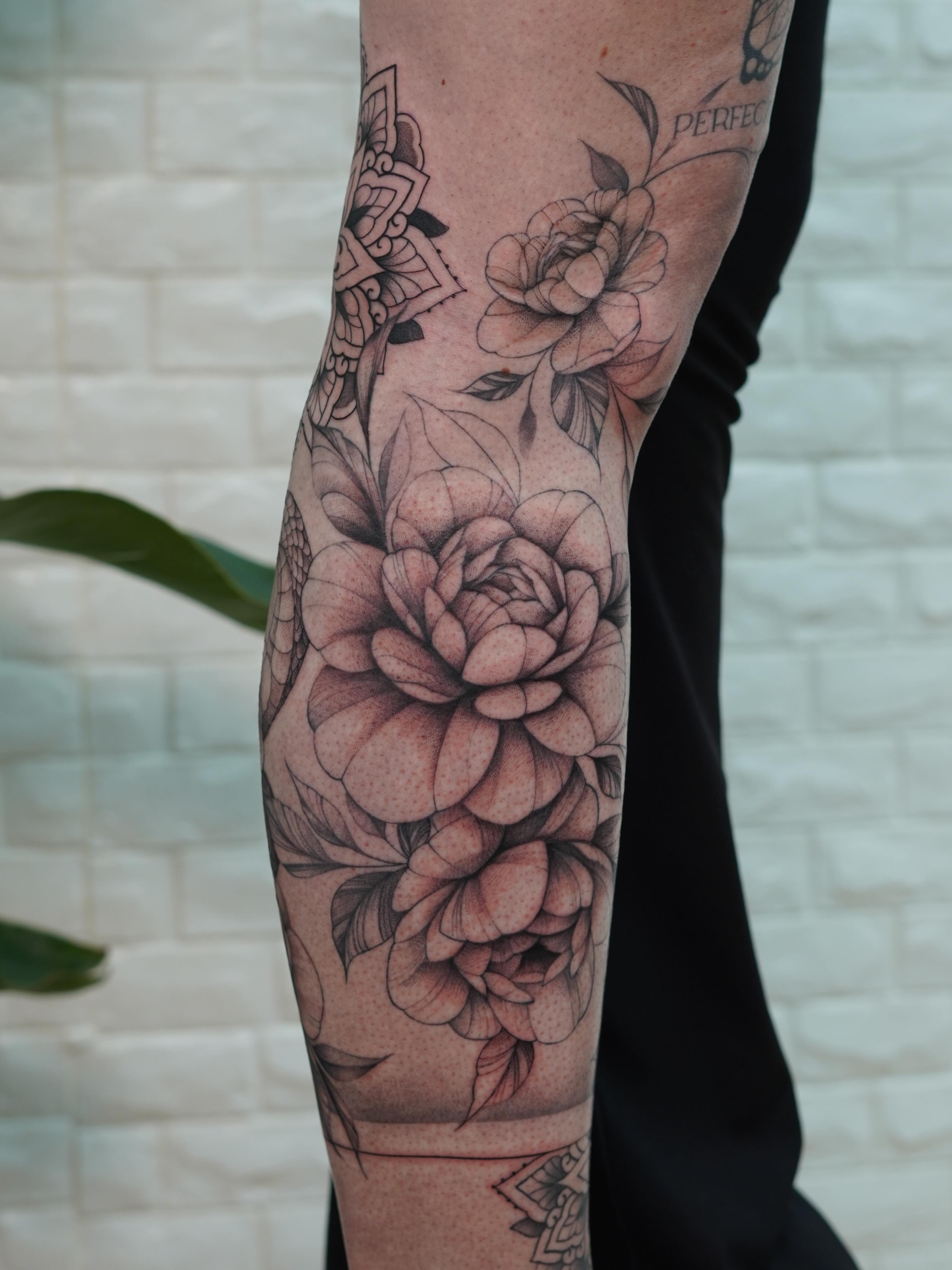 Floral bouquet realism tattoo on the forearm by Danae Andino