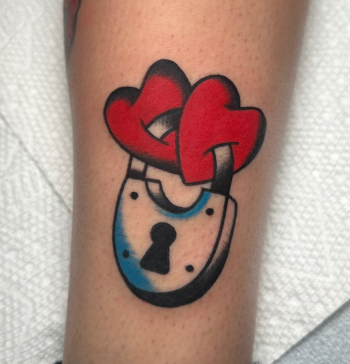 Lock and hearts American traditional tattoo on the forearm by Zahra Niedermann