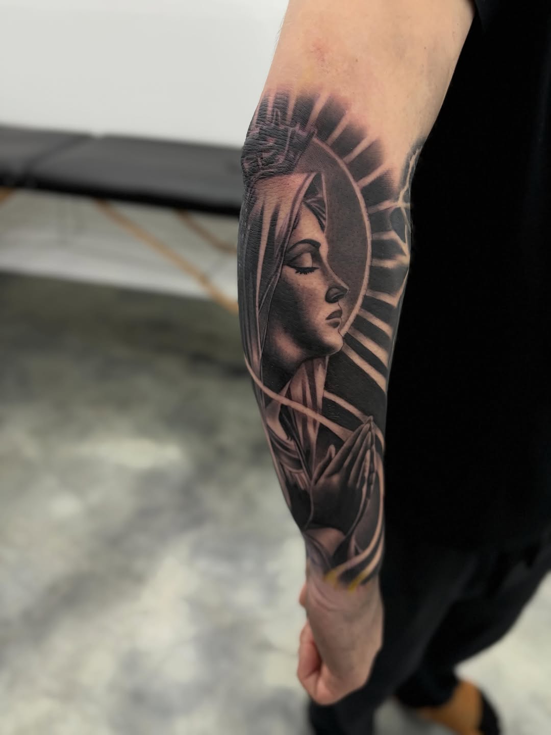 Virgin Mary with praying hands Chicano tattoo on the forearm by Devin