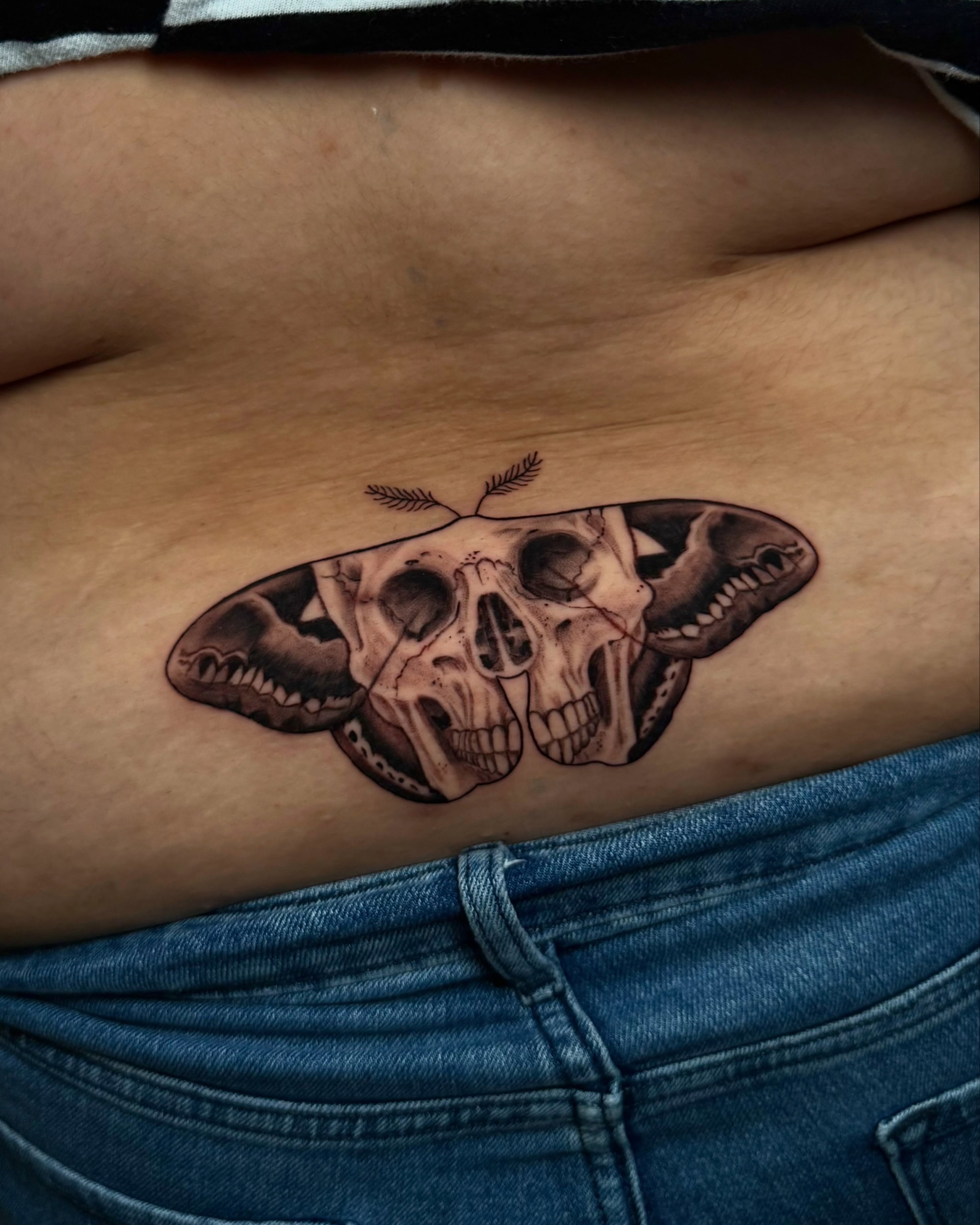 Skulls and moth realism tattoo on the ribs by Too Zen