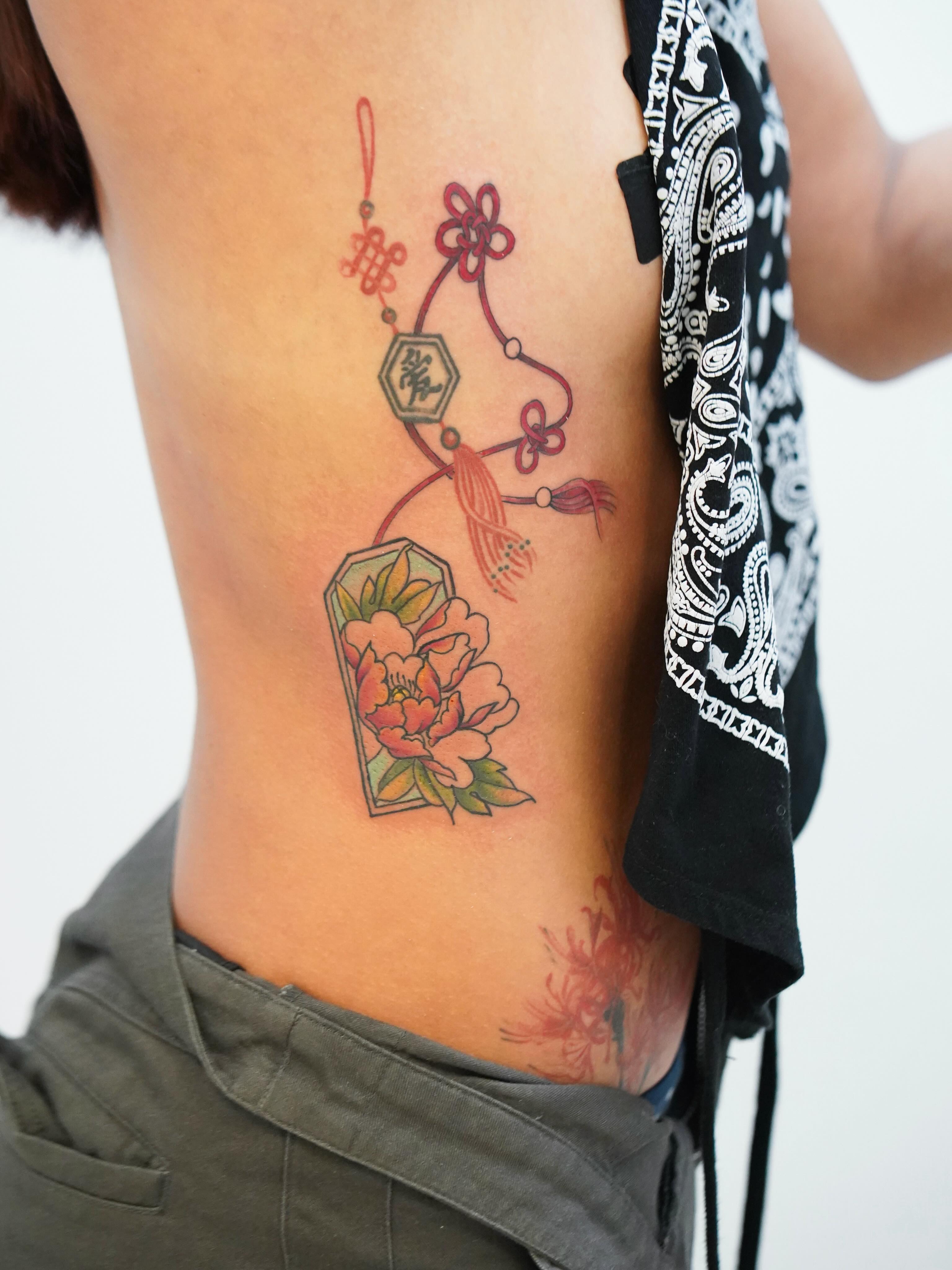Peony and lantern American traditional tattoo on the ribs by Skylar