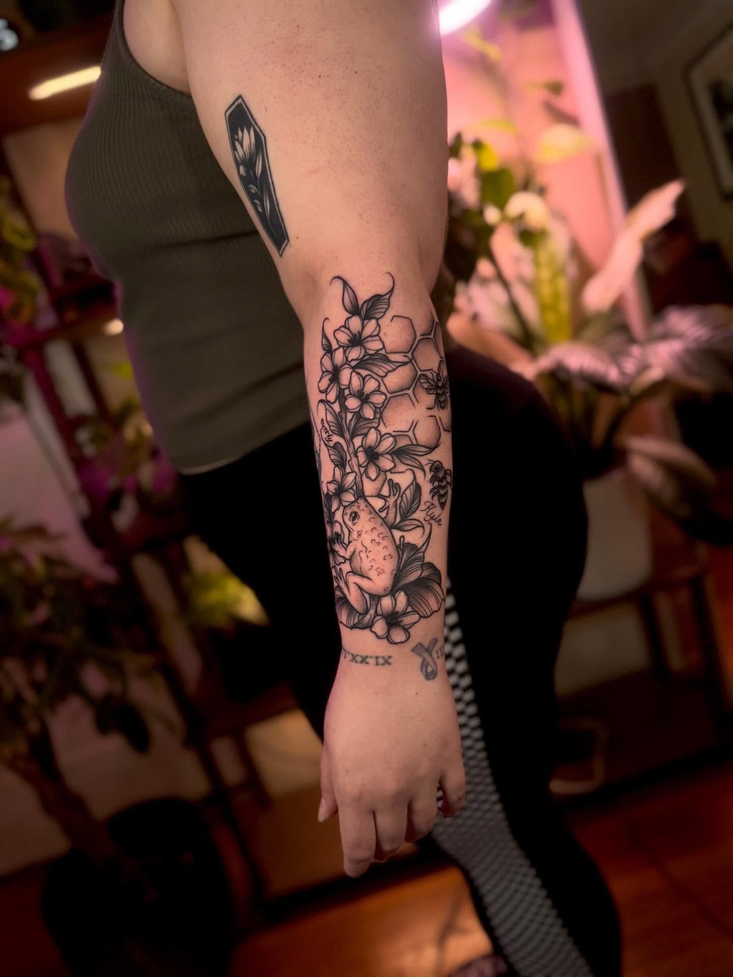 Floral arrangement black and grey tattoo on the forearm by Angie Cotton