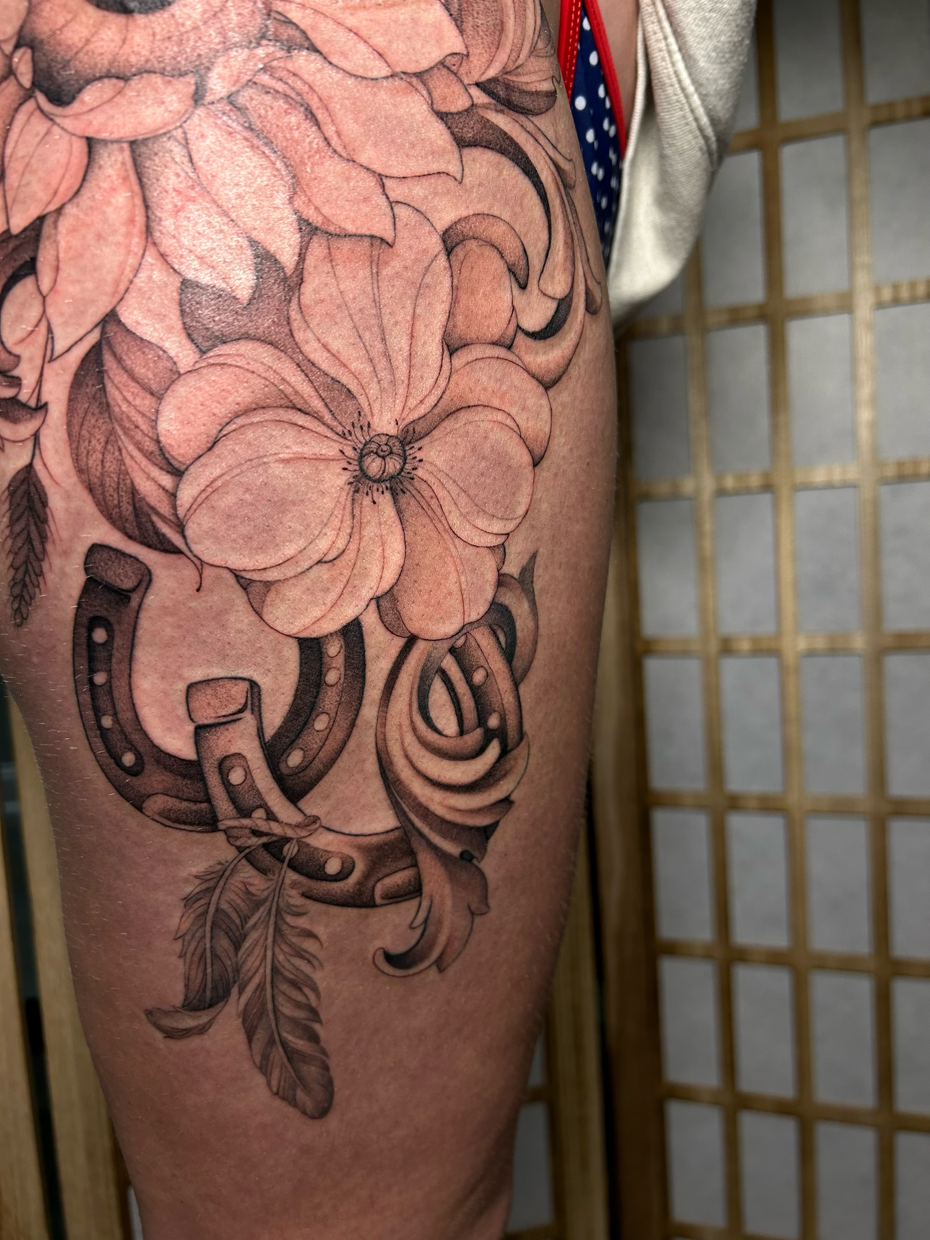 Flowers and horseshoe black and grey tattoo on the thigh by alyssa jade ⭐️