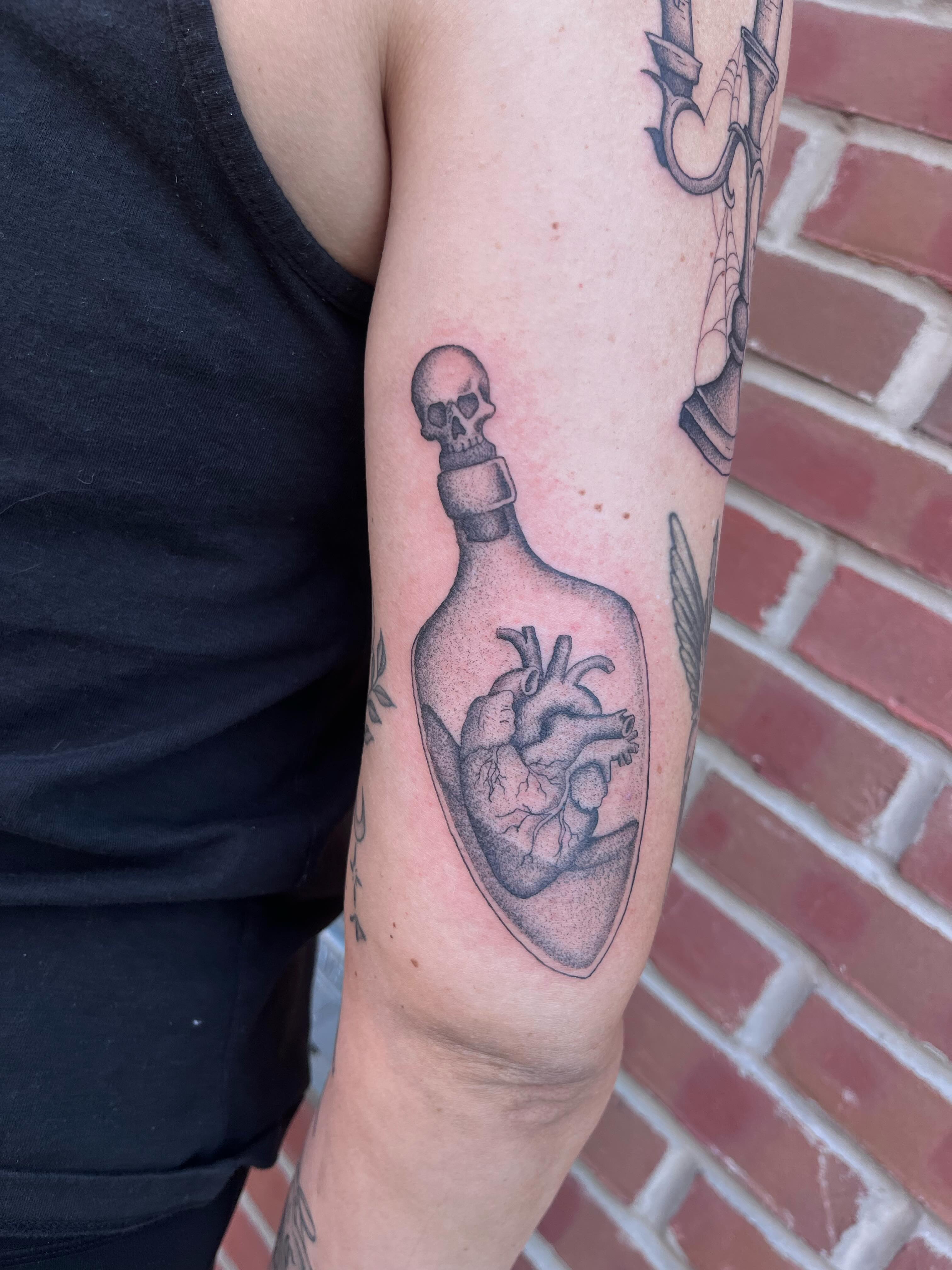 Heart in bottle realism tattoo on the forearm by Jackson Kirchhoff