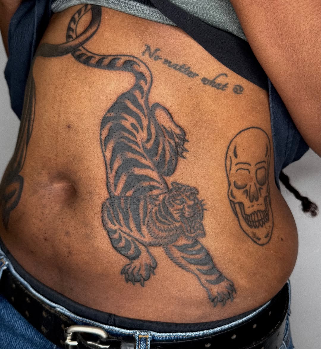 Tiger and skull black and grey tattoo on the torso by nicky joe
