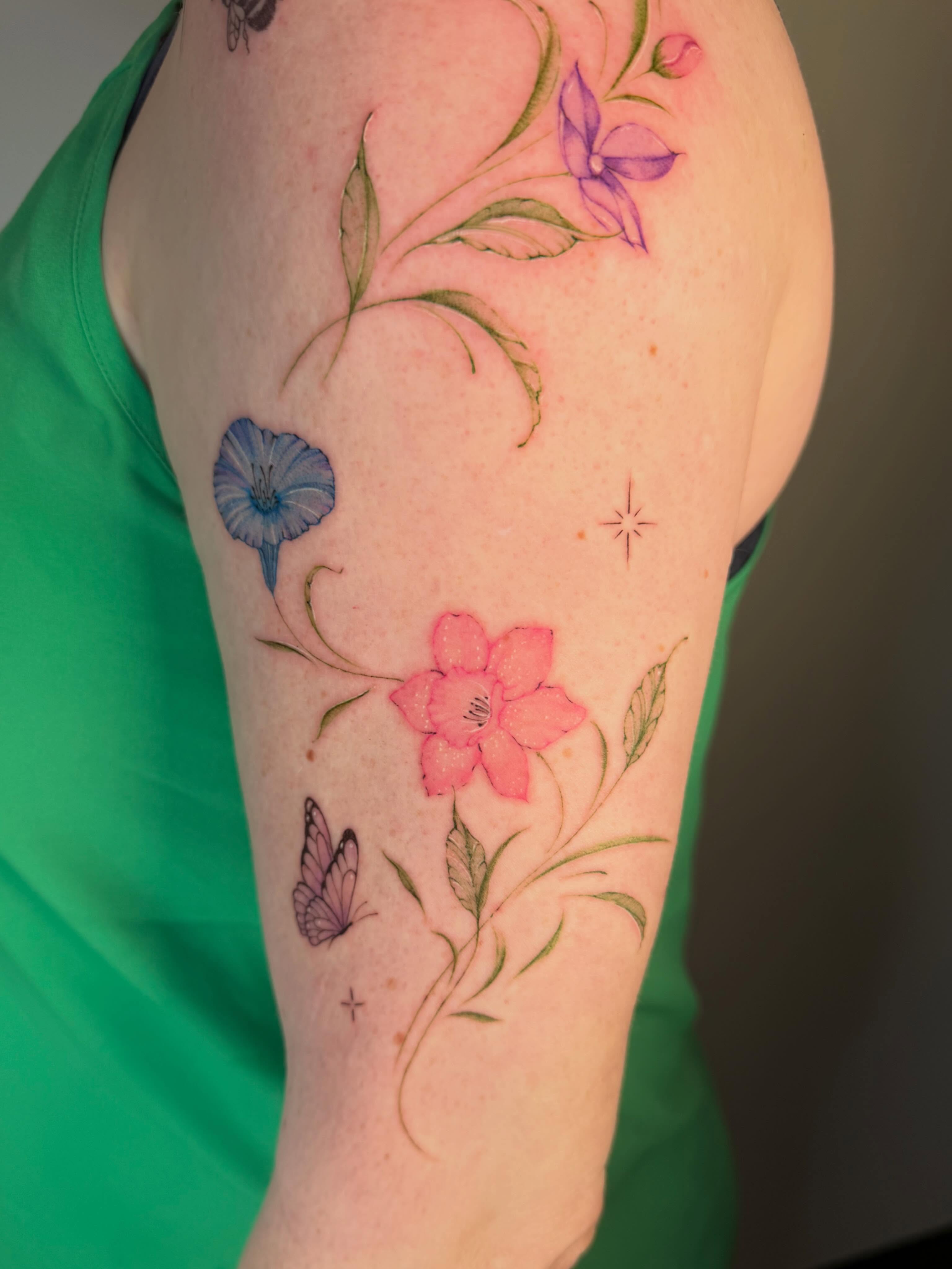 Floral arrangement watercolor tattoo on the forearm by Seattle Fine Line Tattoo