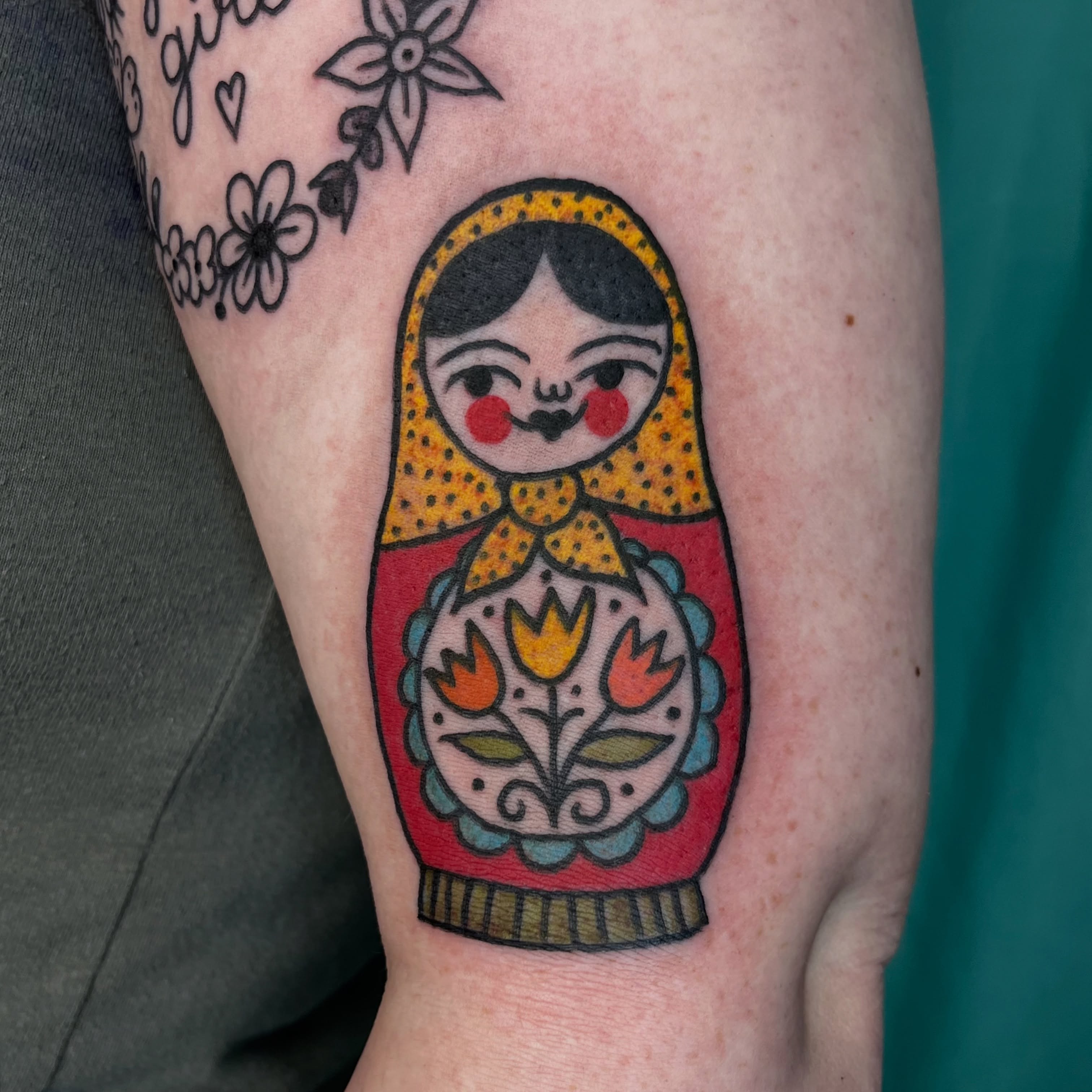 Matryoshka doll American traditional tattoo on the forearm by Kaily McKee