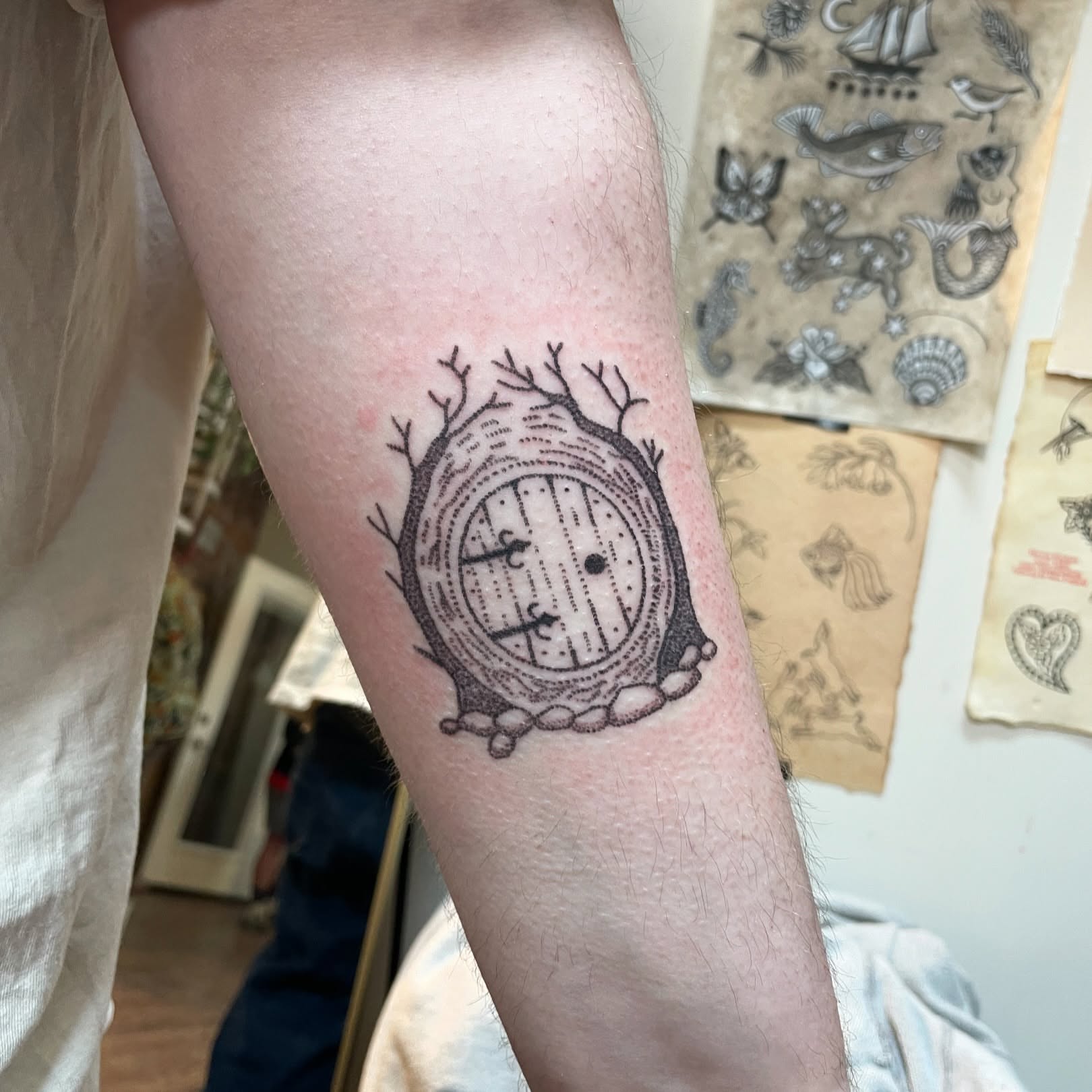 Round door with branches dotwork tattoo on the forearm by Roe
