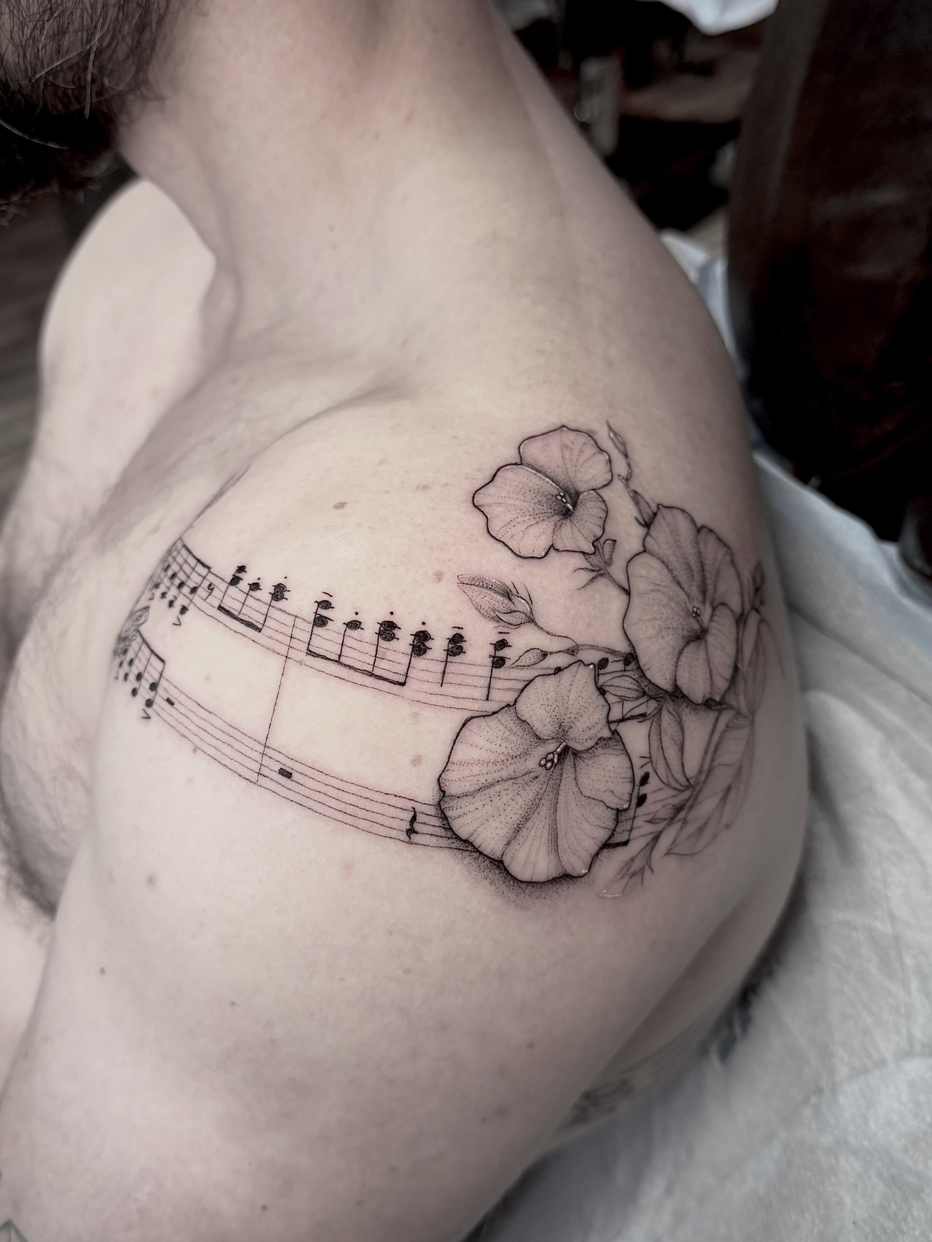 Sheet music and flowers black and grey tattoo on the shoulder by Tattoos by Robyn Pallotta, Austin, Texas
