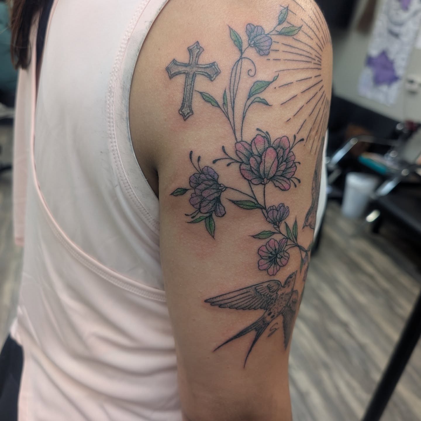 Cross, flowers, bird neo-traditional tattoo on the upper arm by Talia Zula, Loveland, Ohio