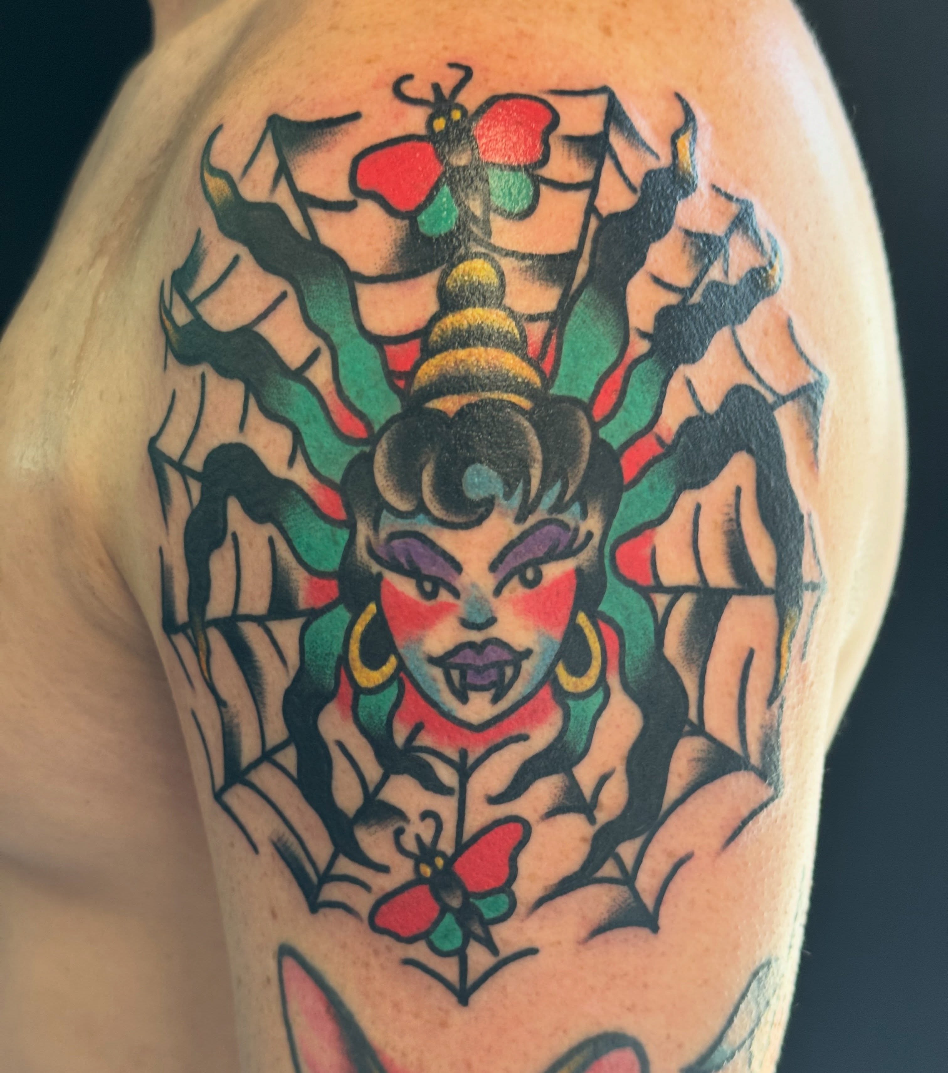Woman with butterfly American traditional tattoo on the upper arm by Kenny Kastro
