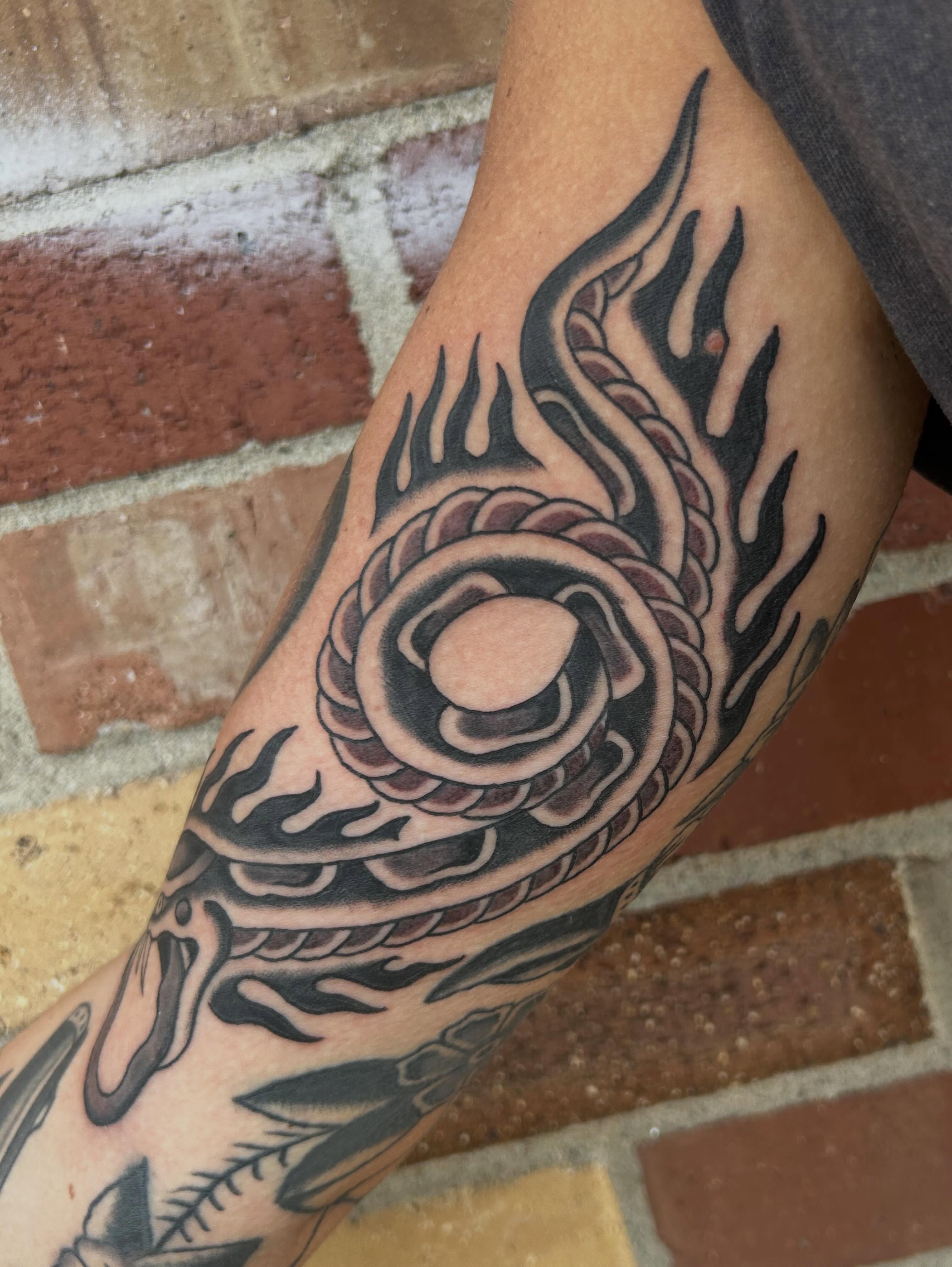 Flame and circular pattern black and grey tattoo on the forearm by Donny