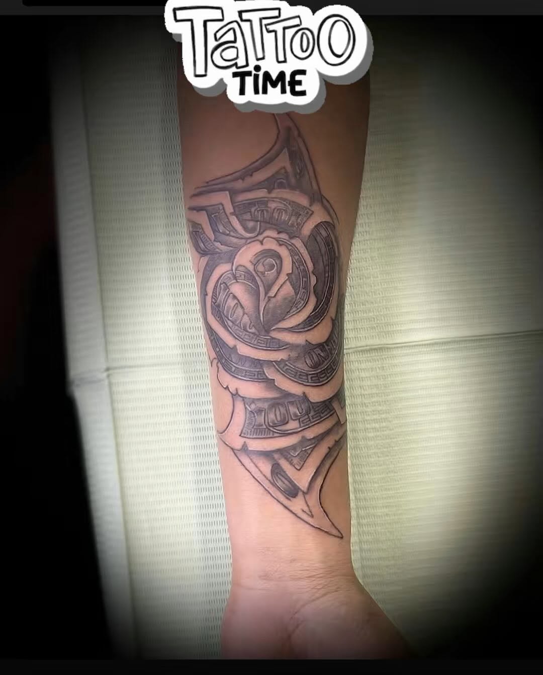 Rose made of money lettering tattoo on the forearm by Christhian King