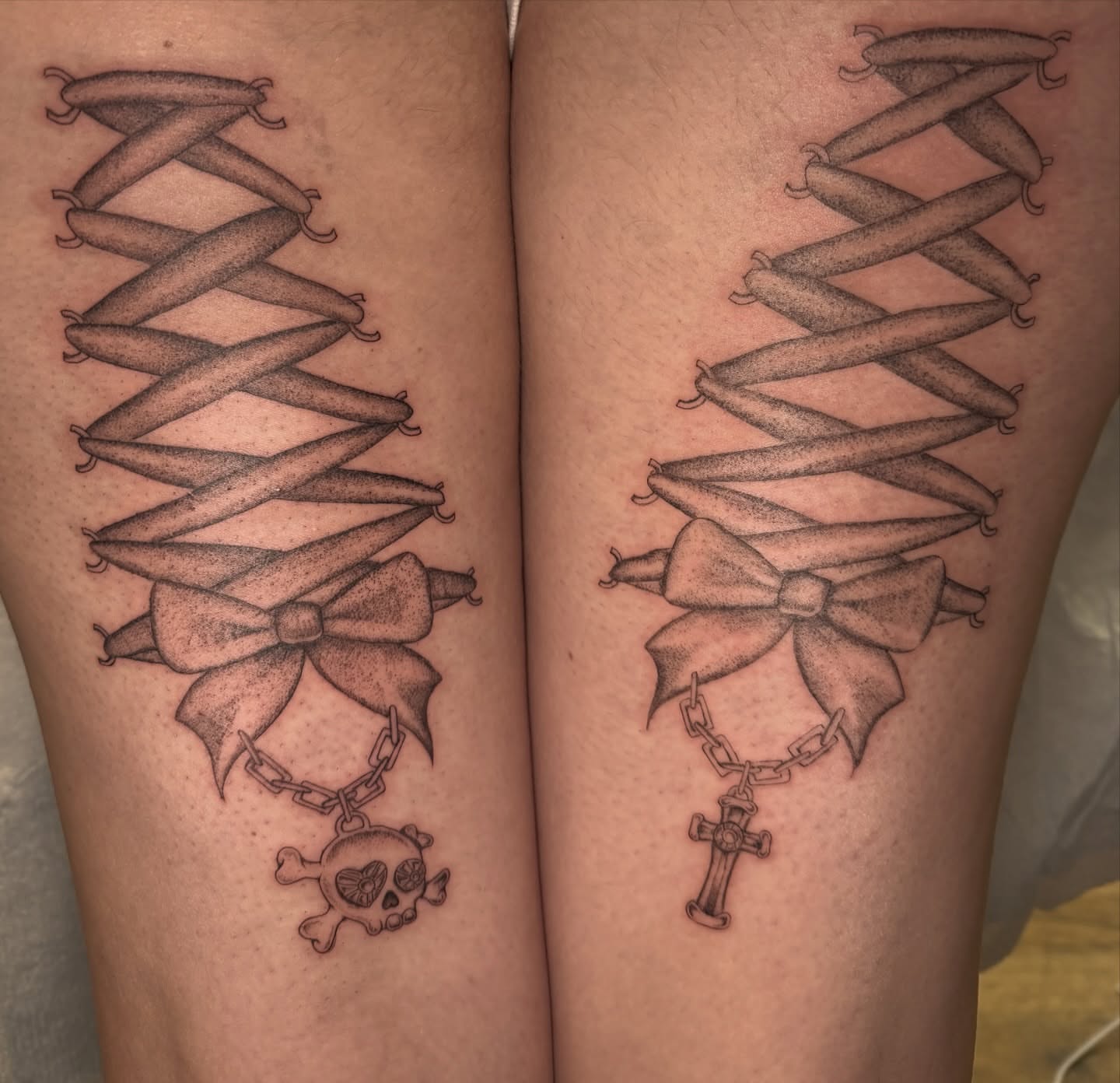 Corset and bow black and grey tattoo on the thigh by Maddie Blosser, Portland, Oregon