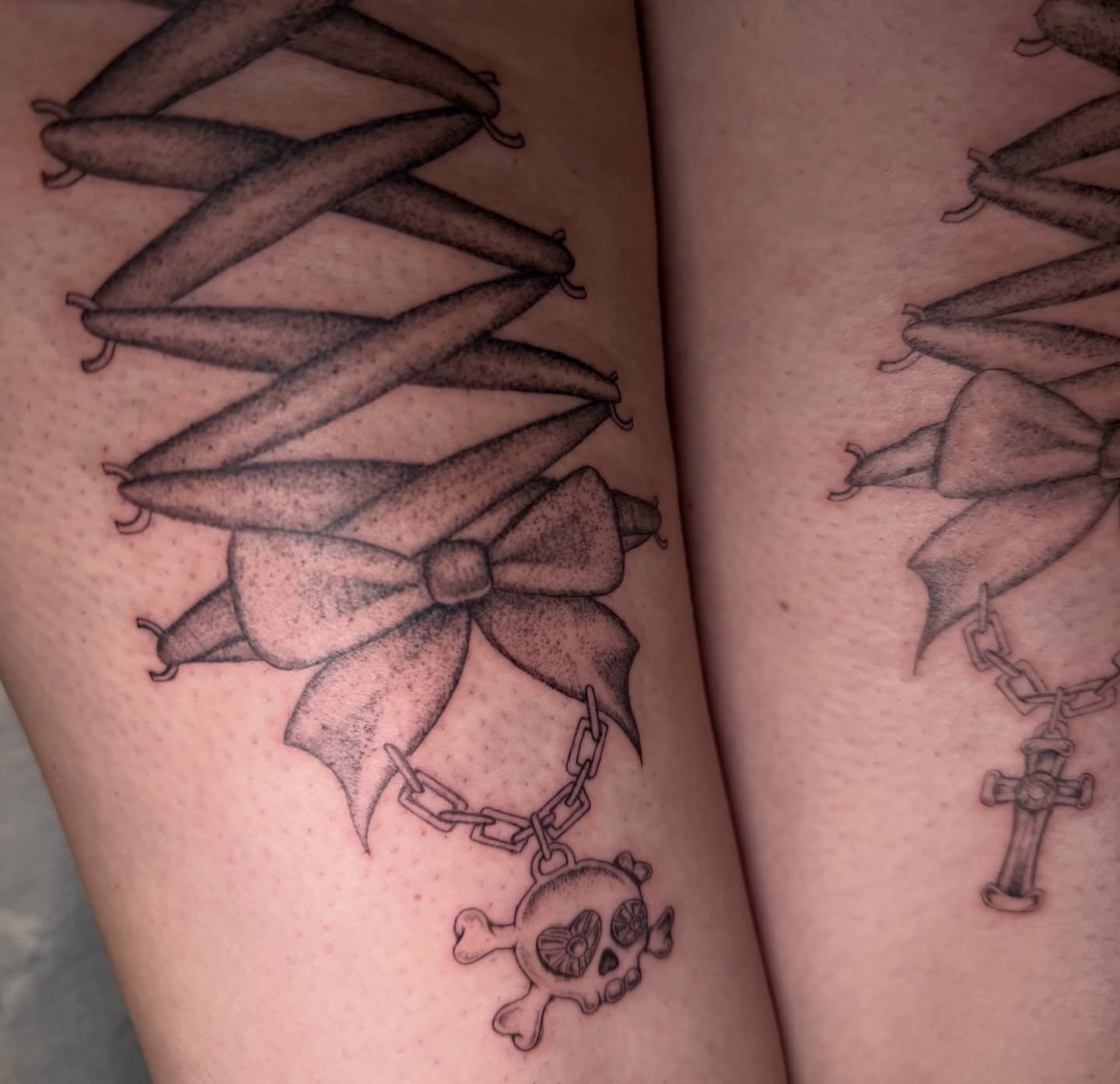 Bow and skull black and grey tattoo on the thigh by Maddie Blosser, Portland, Oregon