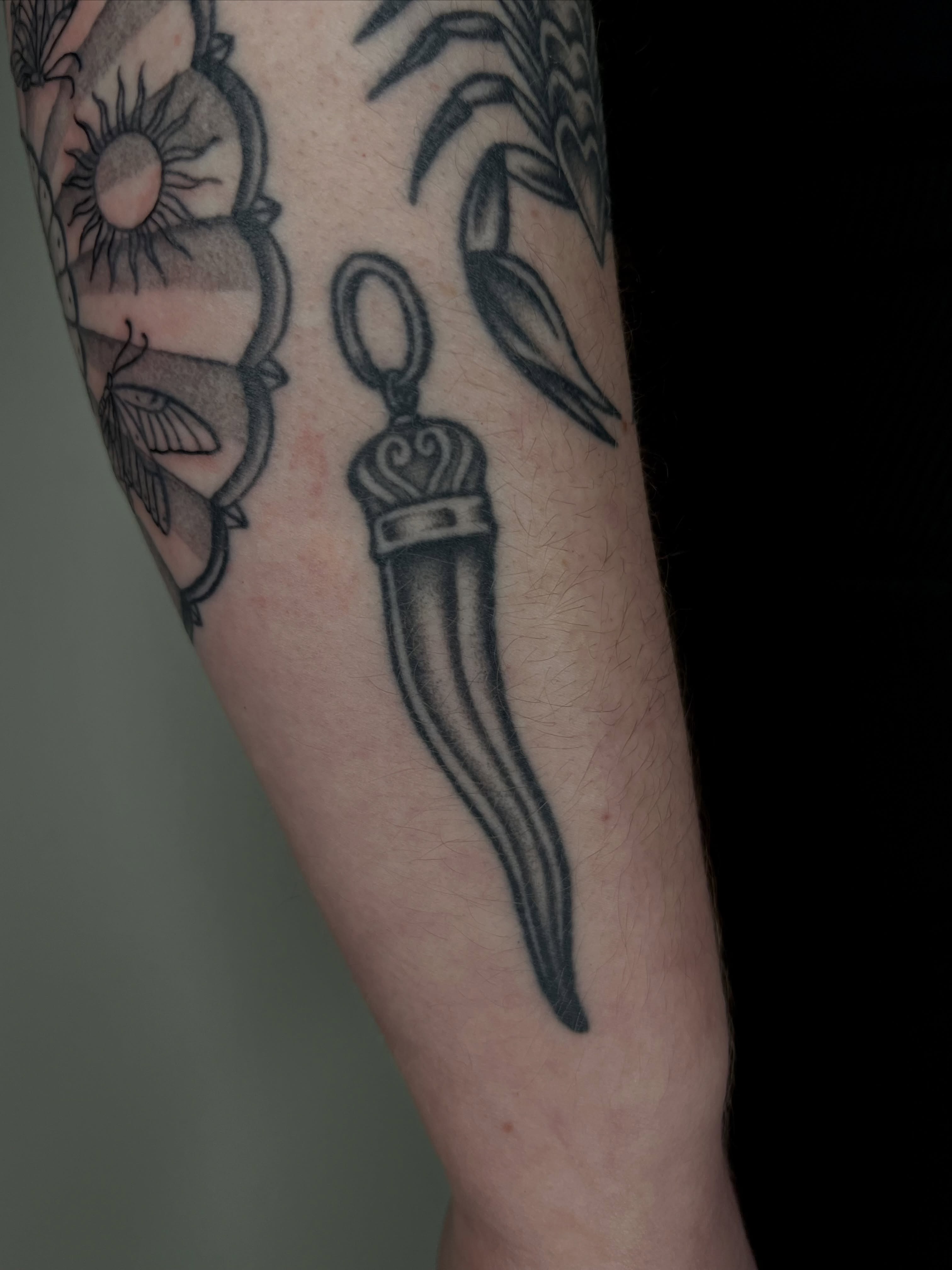 Knife black and grey tattoo on the forearm by Patrick Elijah