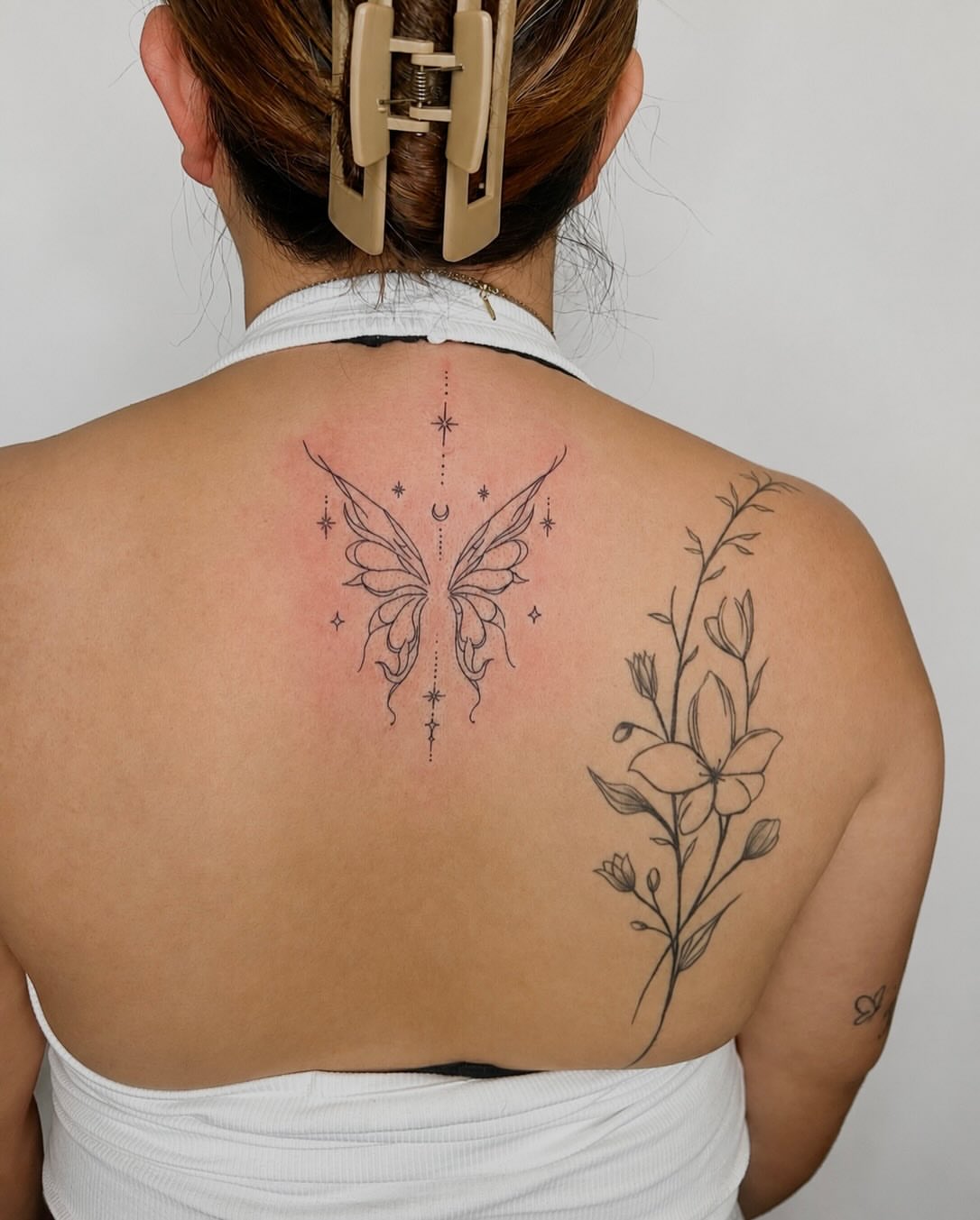 Butterfly and floral fine line tattoo on the back by 𝒜𝓇𝓉𝒾𝓈𝓉 𝒟𝒶𝒾𝓈𝓎 ♡