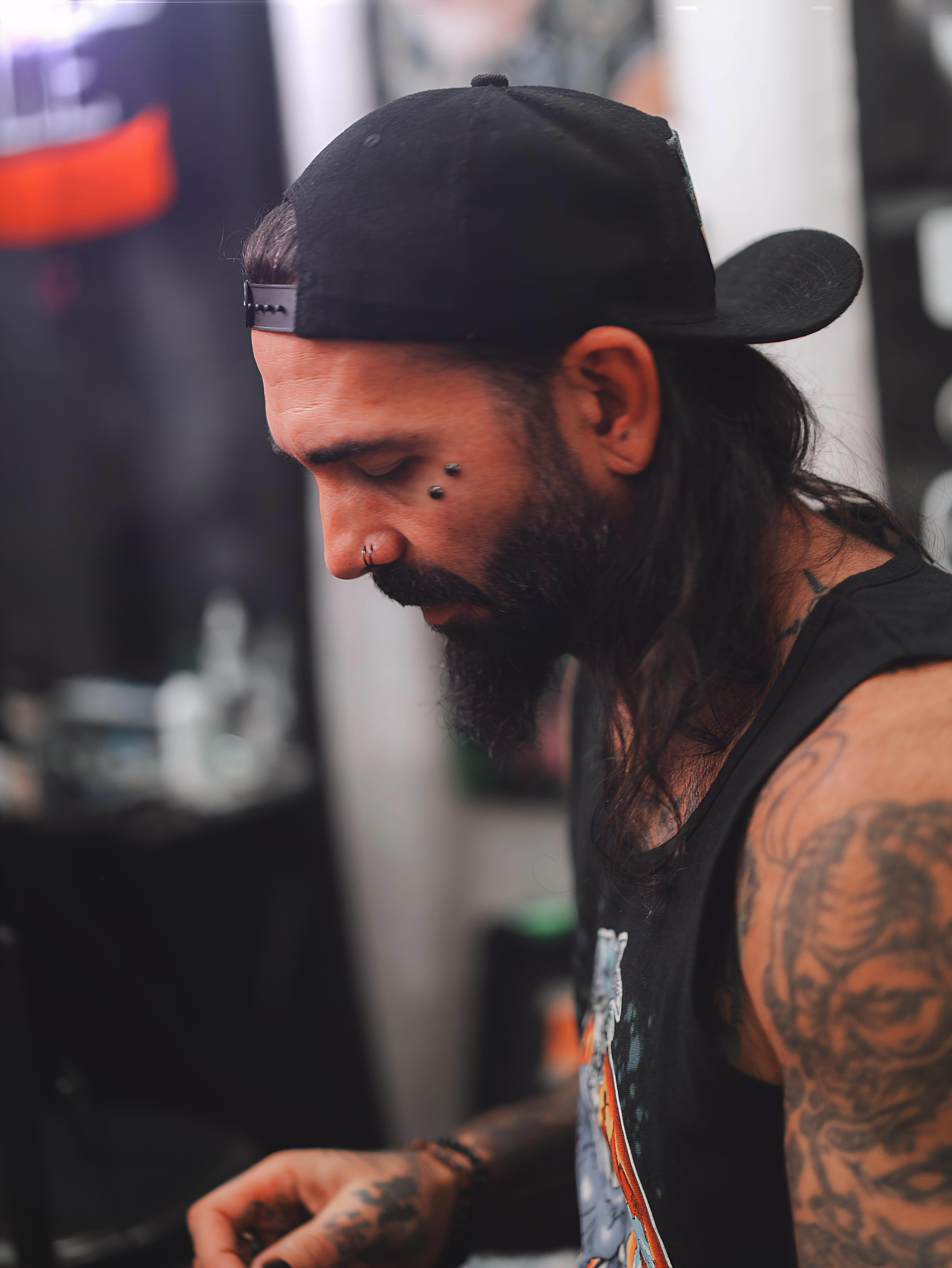 Bearded man black and grey tattoo on the chest by Don Peddicord