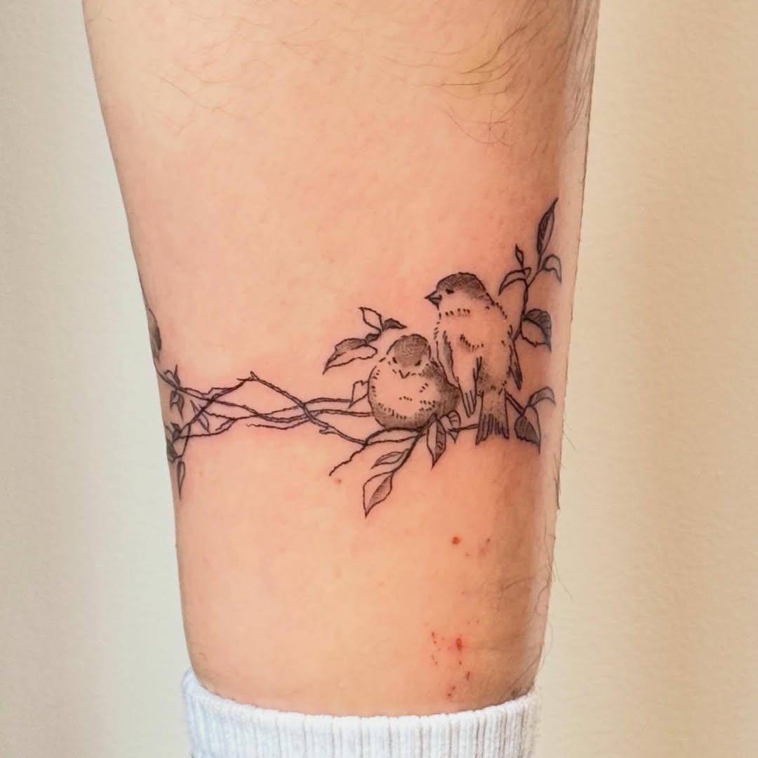 Two birds on a branch fine line tattoo on the forearm by Kirsten