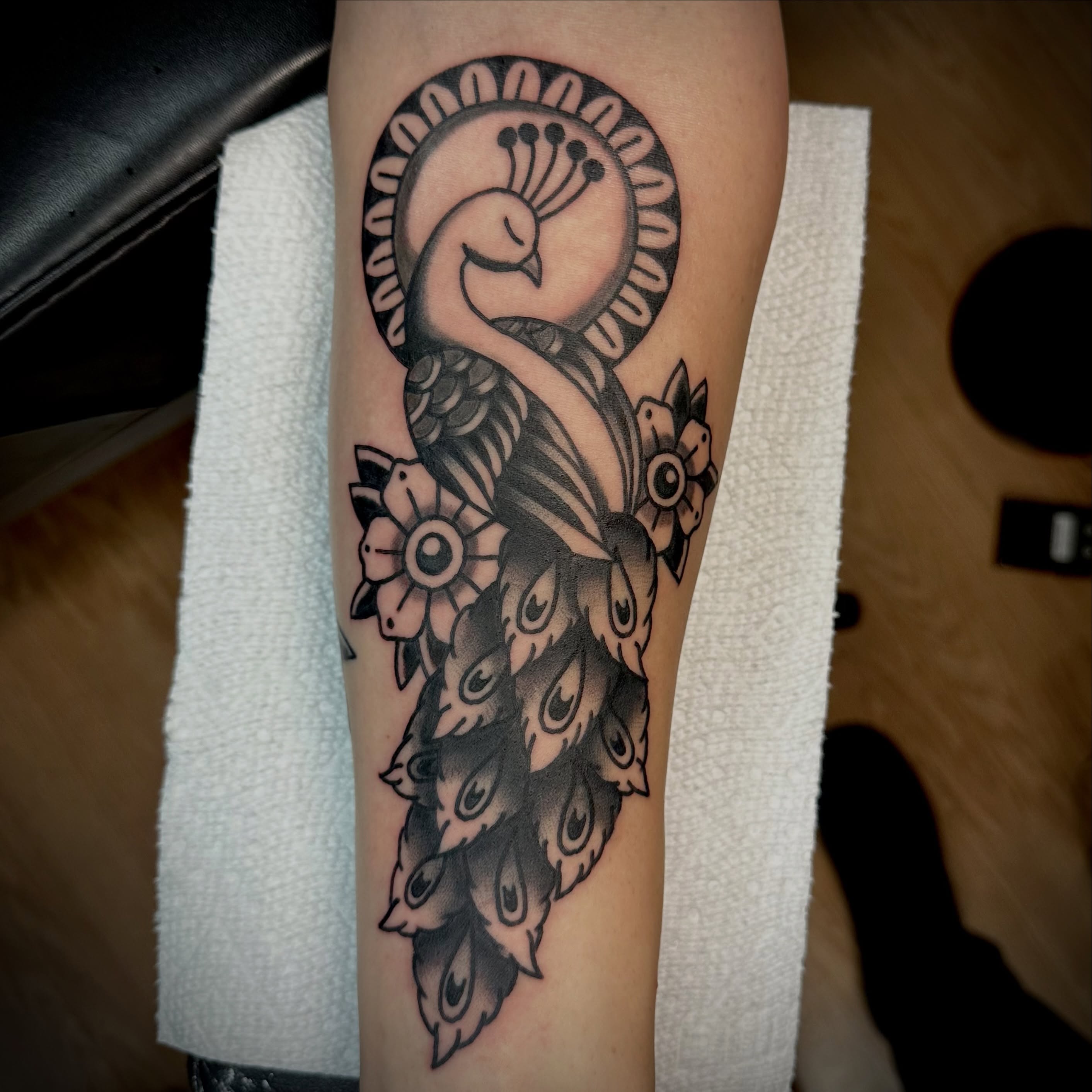Peacock black and grey tattoo on the forearm by Josh Robinson