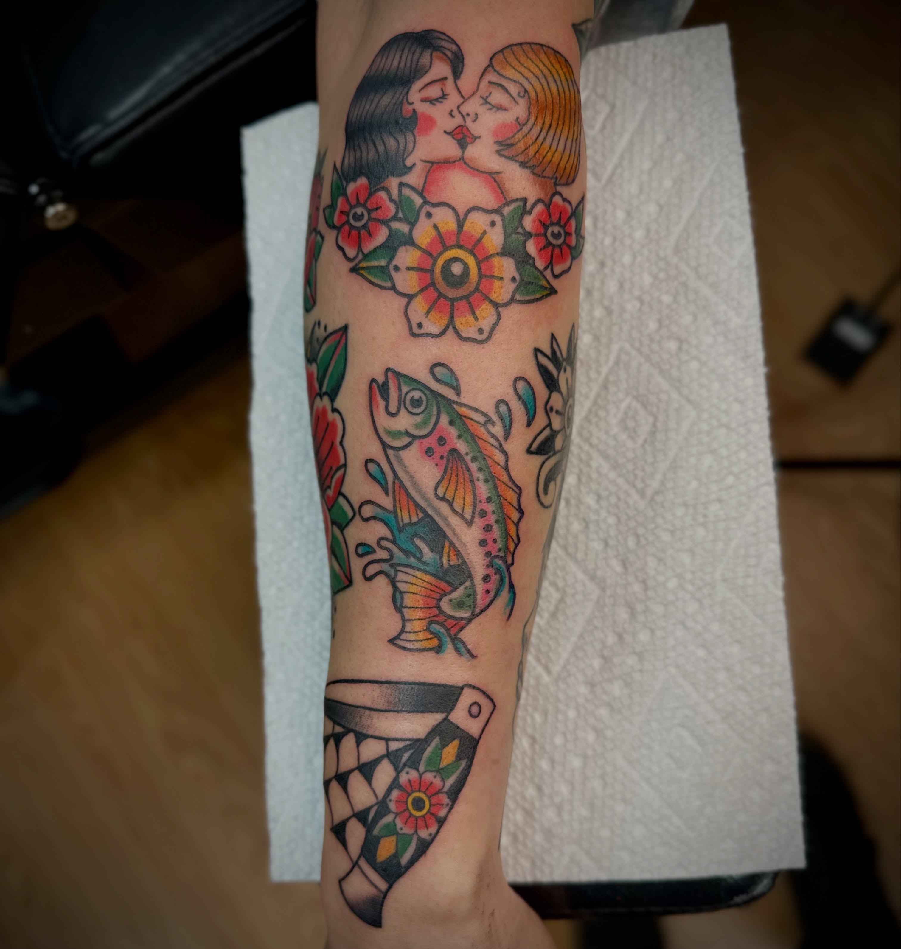 Kissing couple with fish American traditional tattoo on the forearm by Josh Robinson