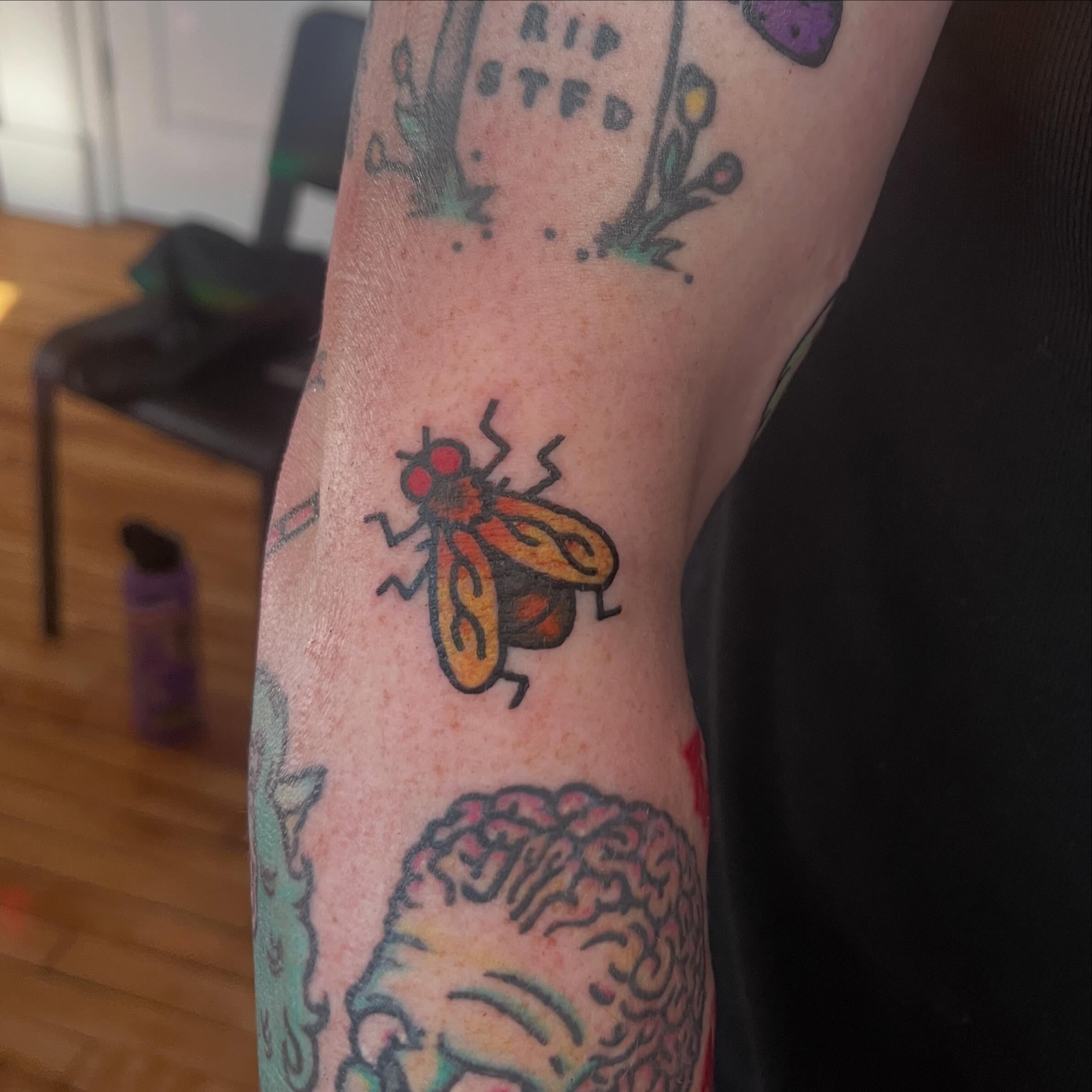 Fly trash polka tattoo on the forearm by madelynne (maddie) caldwell tattoos
