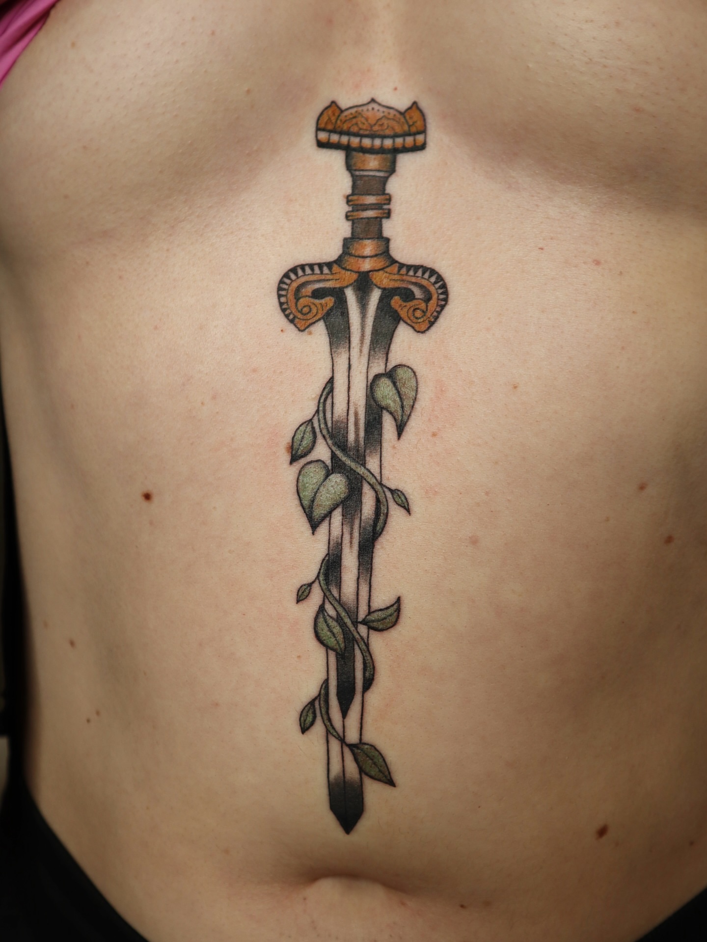 Sword with vines neo-traditional tattoo on the ribs by Kate Ortiz