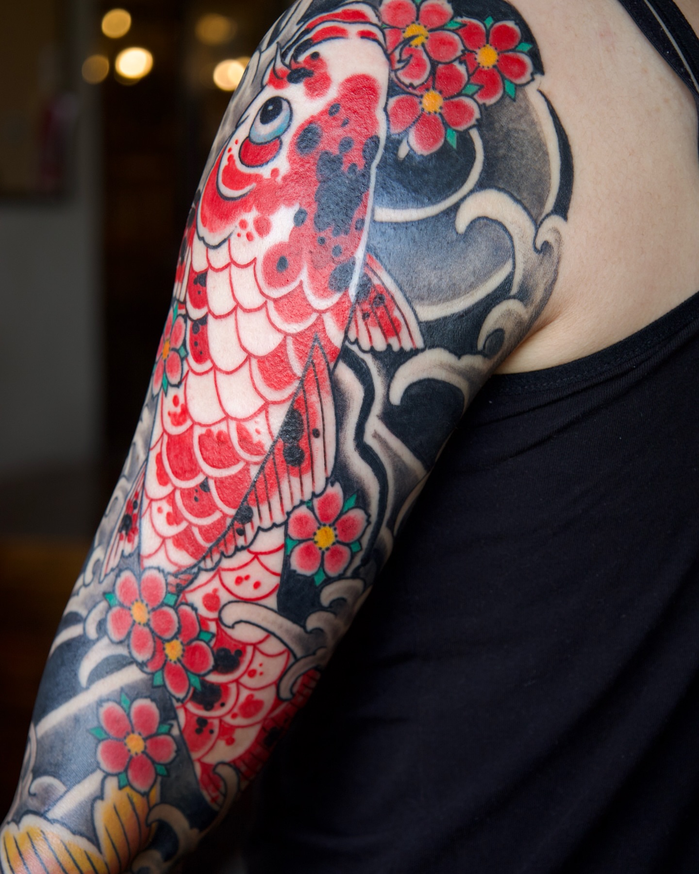 Koi fish and cherry blossoms japanese irezumi tattoo on the upper arm by Marcos Rivera, Laredo, Texas