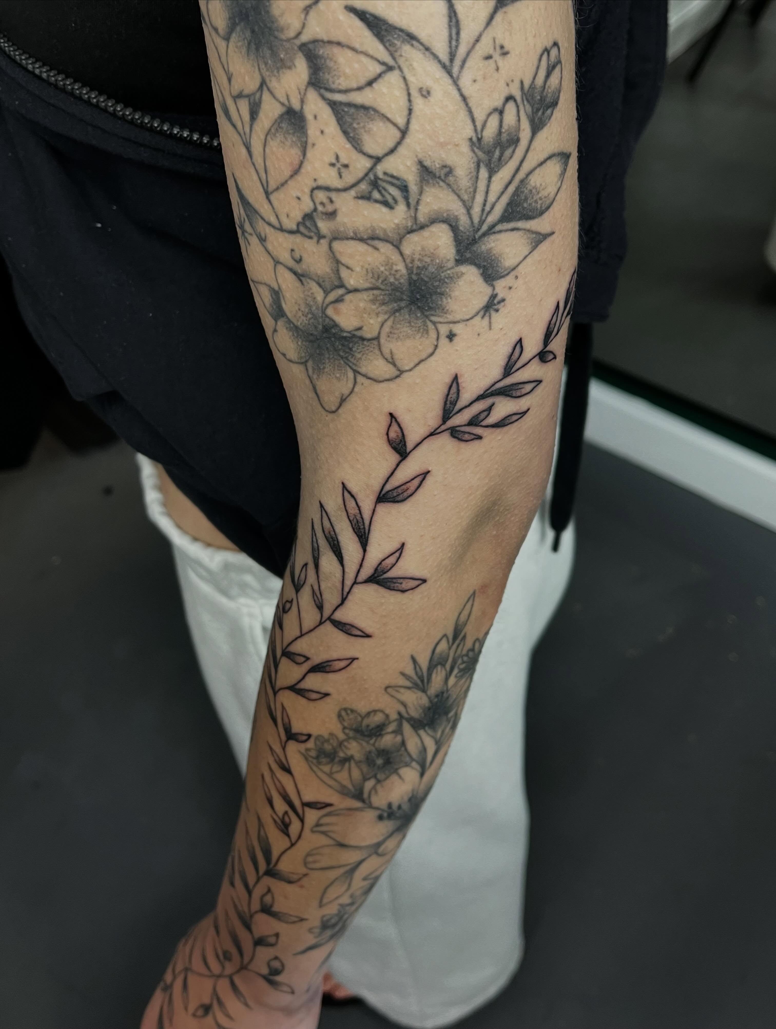 Floral arrangement black and grey tattoo on the forearm by Mason McCubbin
