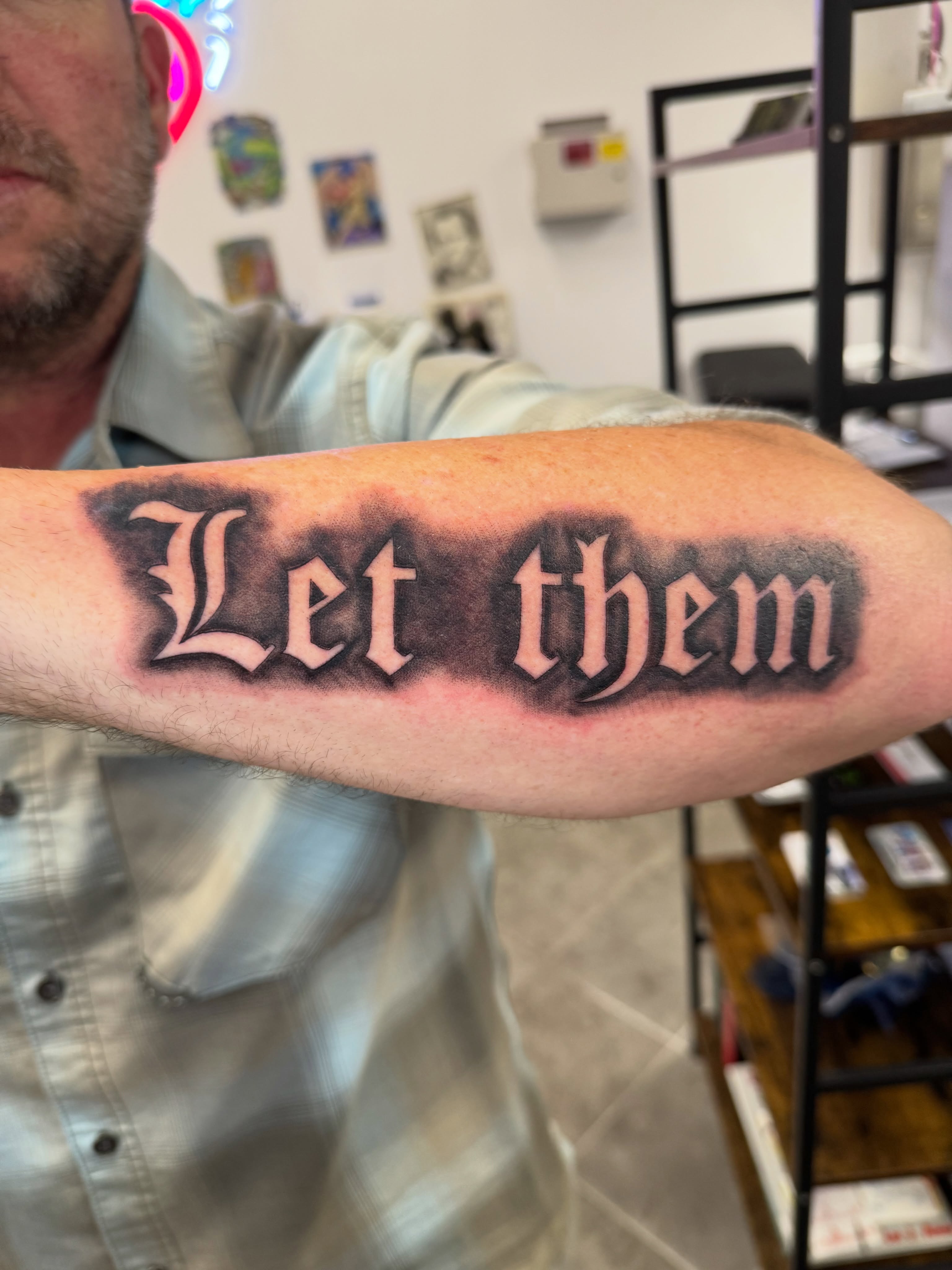 Let them lettering script tattoo on the forearm by Juan Guzman