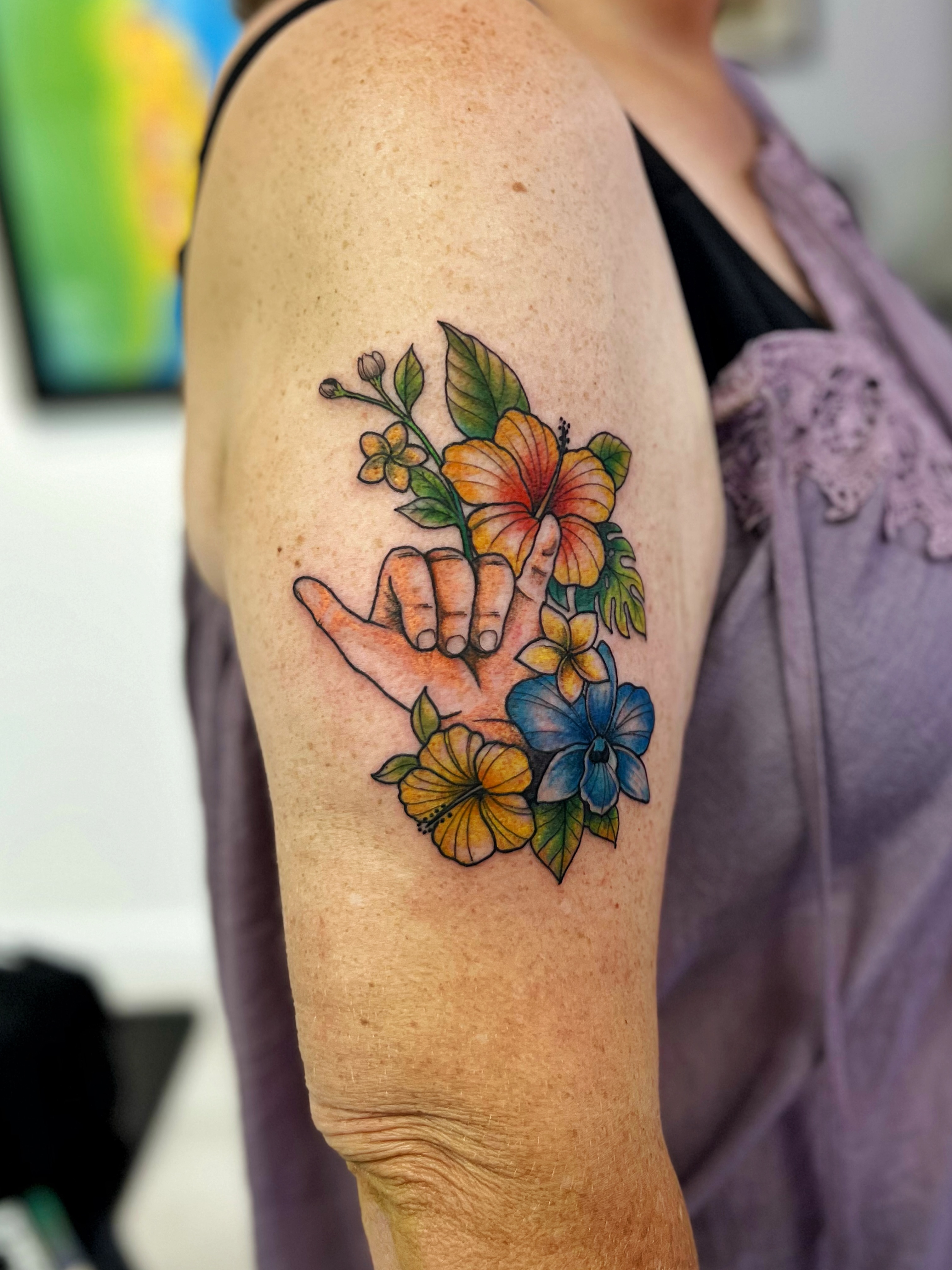 Hand with flowers new school tattoo on the upper arm by ๐ฎ๐๐๐๐๐ ๐ท ๐ฒ๐๐๐๐