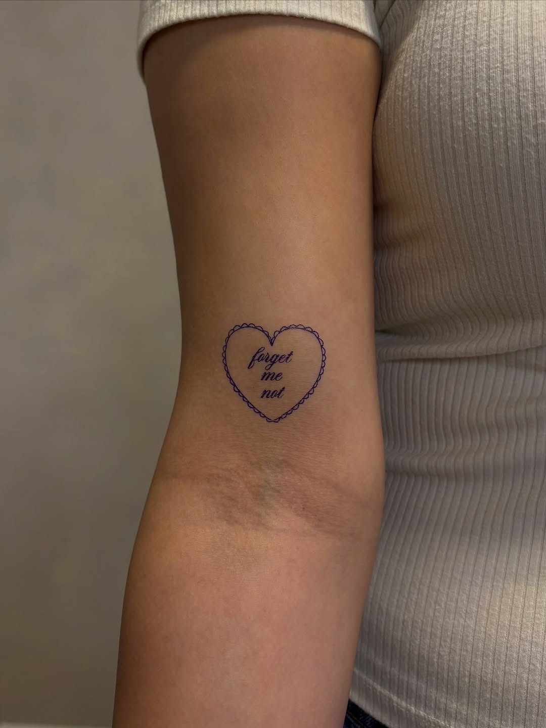 Heart with text minimalist tattoo on the forearm by Valentina