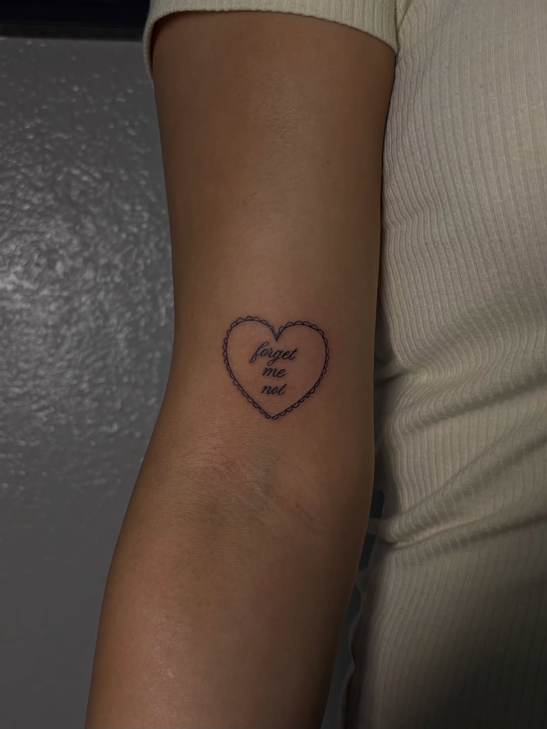 Heart with text minimalist tattoo on the forearm by Valentina